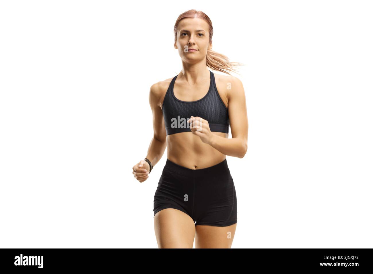 Weibliche Sportlerin im Laufoutfit joggt isoliert auf weißem Hintergrund zur Kamera Stockfoto