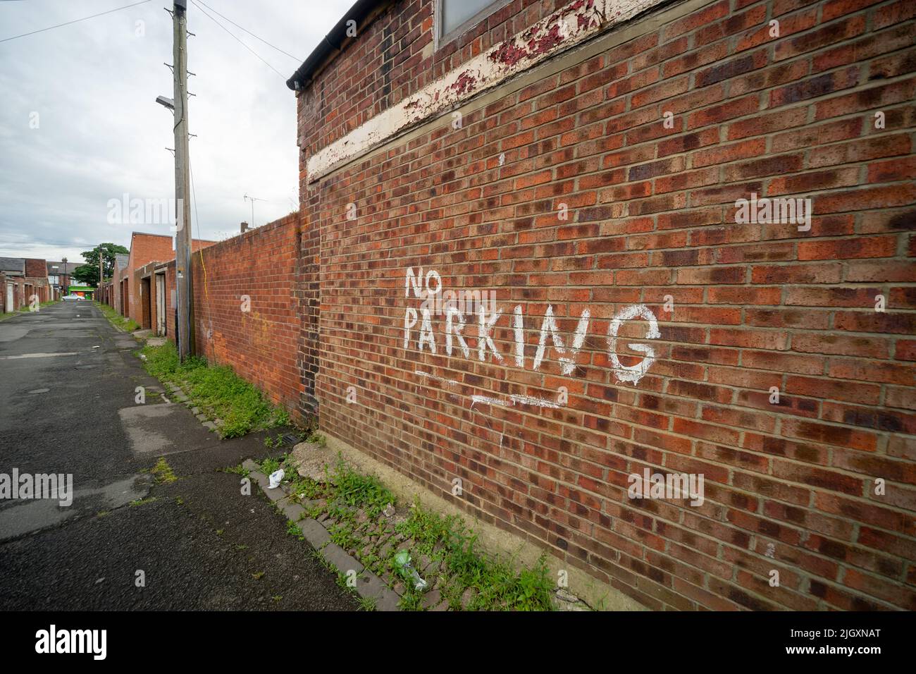 Kein Parkplatz, der auf einer Ziegelmauer auf der Hintergasse, in der Hinterstraße oder in der Nähe einer Reihe von Reihenhäusern, England, Großbritannien, gemalt ist Stockfoto