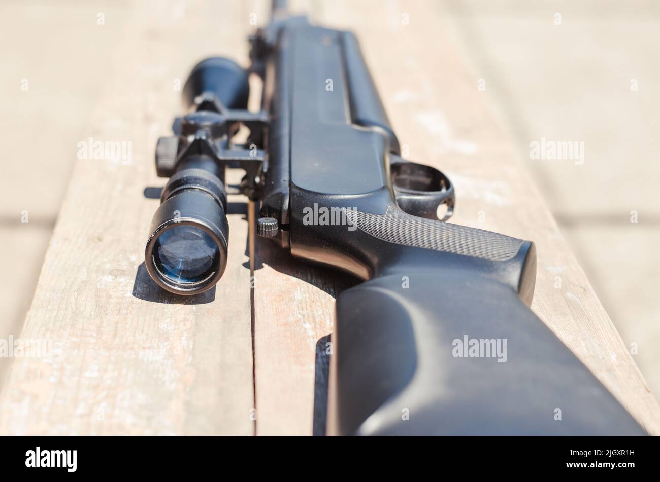 Eine pneumatische Waffe auf einem Holztisch auf einem Schießstand. Schießen  benötigtes Zubehör für den Schießsport. Der dunkle Hintergrund  Stockfotografie - Alamy
