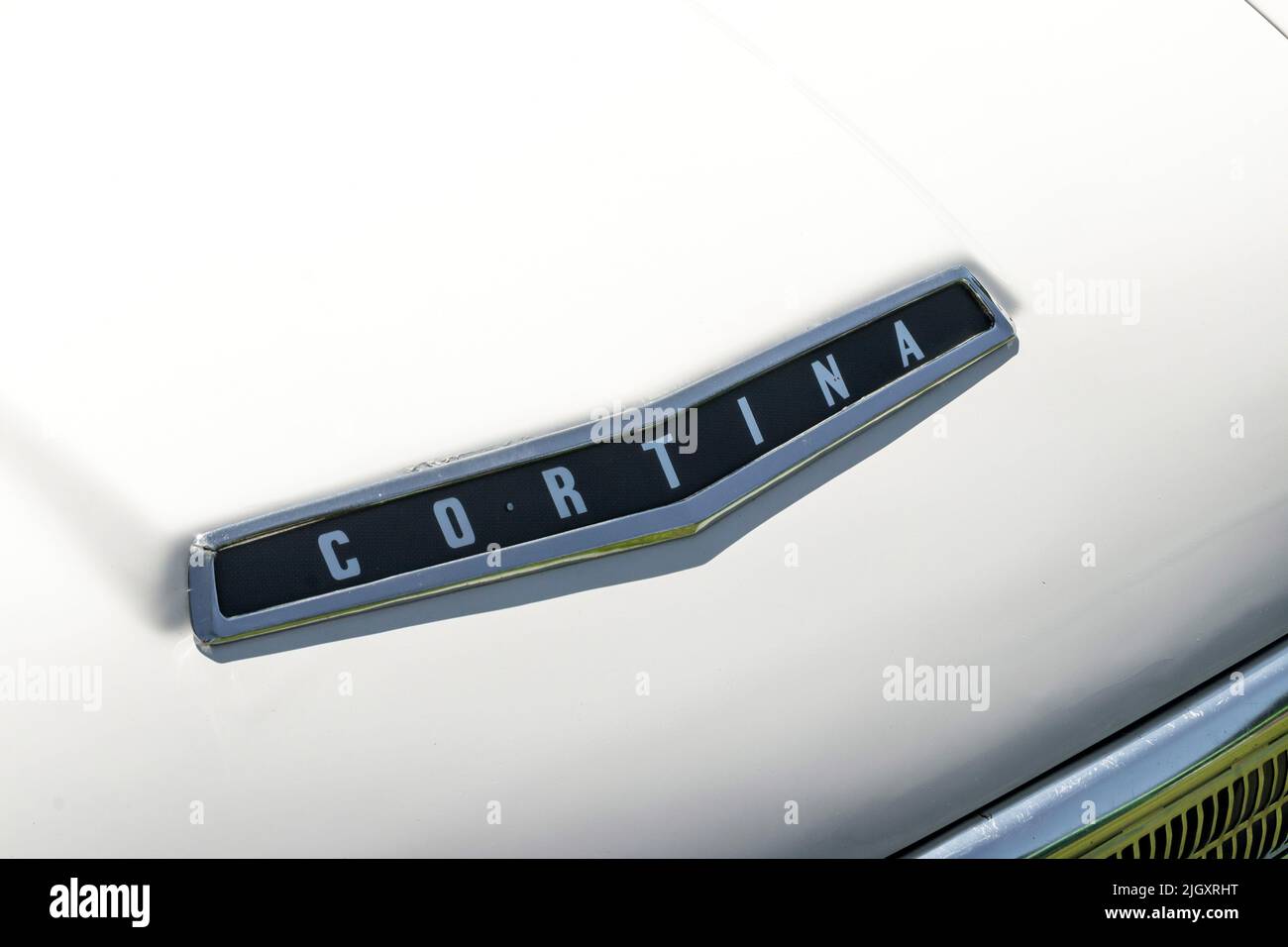 Nahaufnahme des Mk 1 Ford Cortina Motorhaubenabzeichens auf cremefarbenem Lack Stockfoto