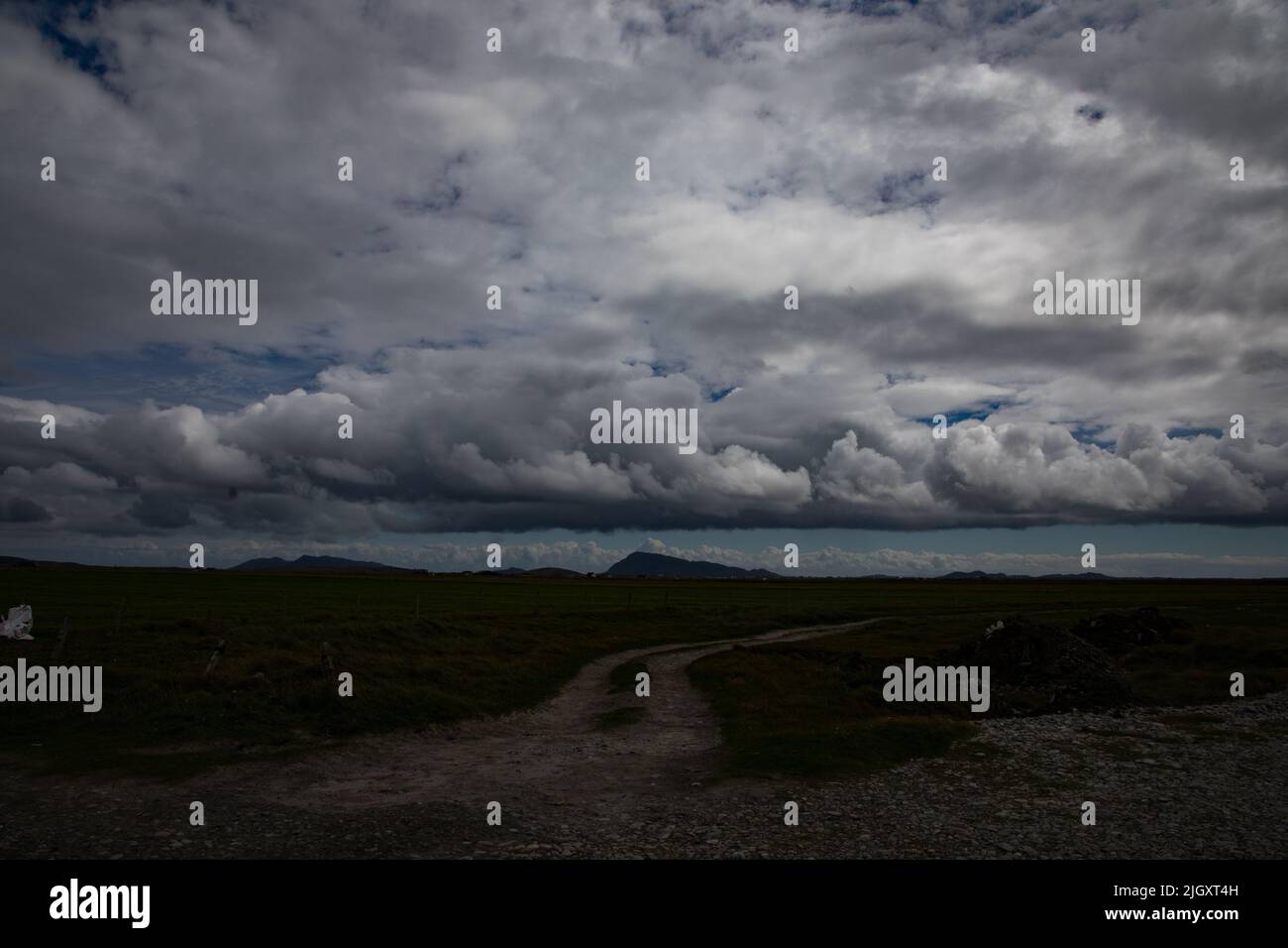 Track durch die Machair, Gearraidh na Monadh, South Uist mit gemischten Wolken Stockfoto