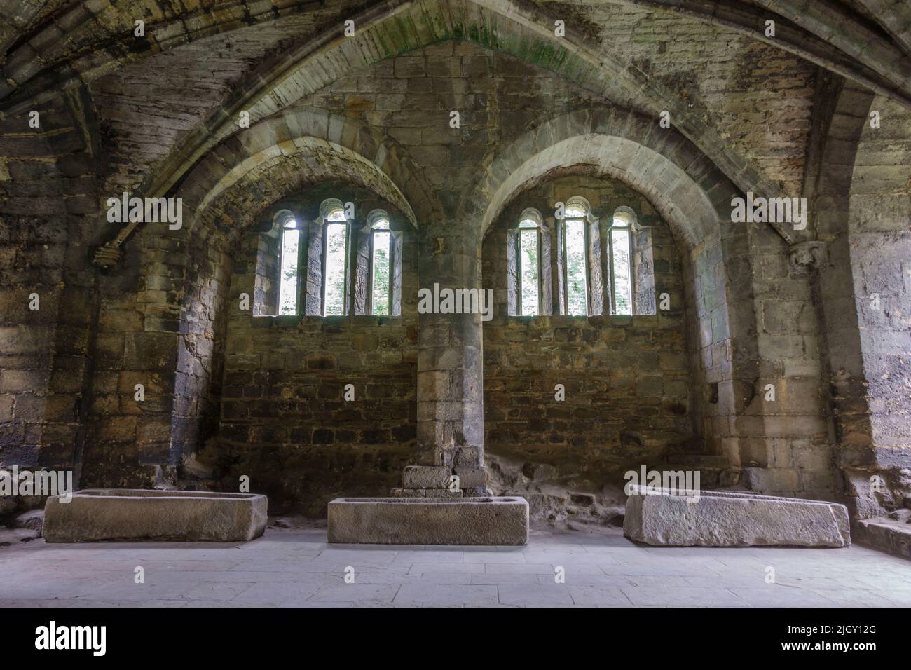 Mehrere Sarkophage im Kapitelhaus, Kirkstall Abbey, einem zerstörten Zisterzienserkloster in Kirkstall, in der Nähe von Leeds, West Yorkshire, England. Stockfoto