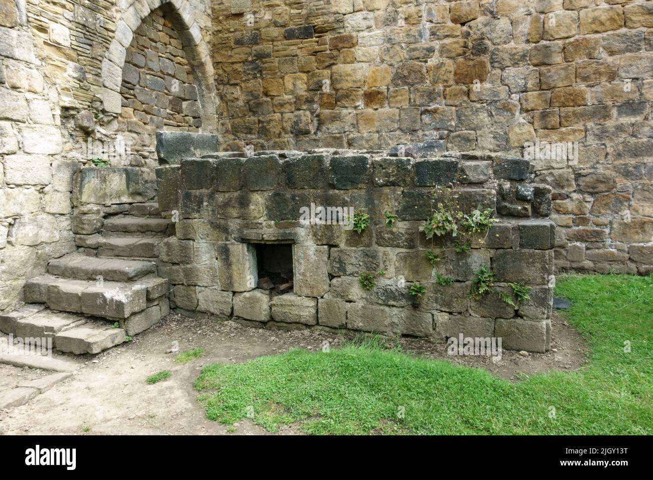 Reste von Kamin im wärmenden Haus Kirkstall Abbey, einem zerstörten Zisterzienserkloster in Kirkstall, in der Nähe von Leeds, West Yorkshire, Großbritannien. Stockfoto