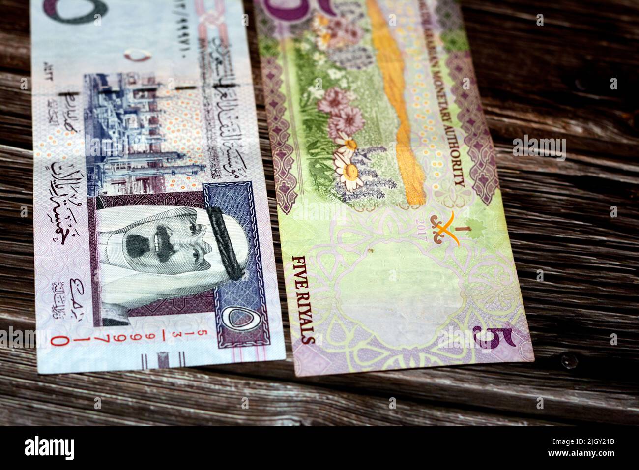 Saudi-Arabien 5 SAR fünf saudische Riyals Bargeld Geldschein mit dem Foto von König Abdullah bin Abdulaziz Al Saud und Blumen isoliert auf einem Holzhintergrund Stockfoto