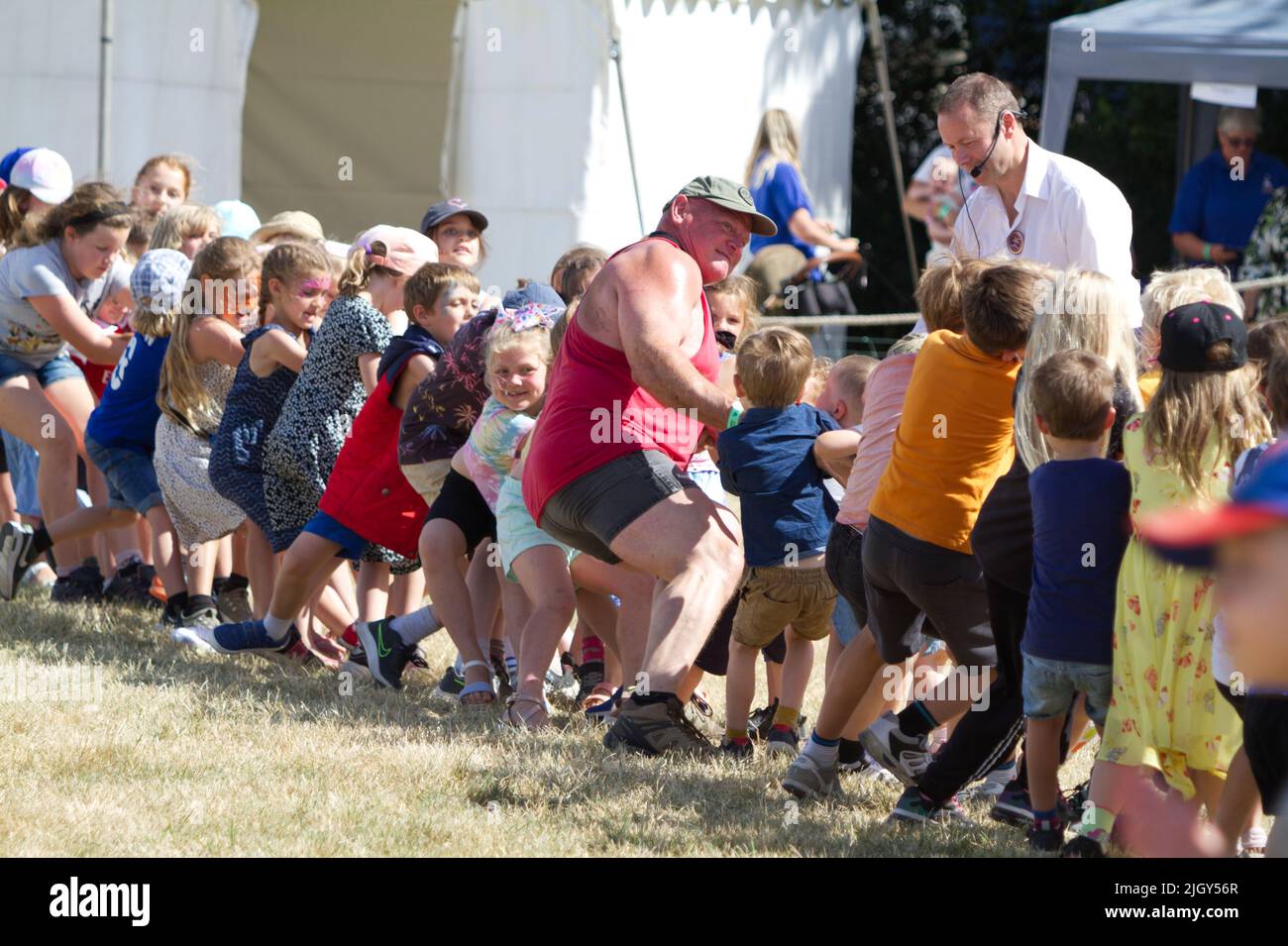 Der Mighty Smith, der starke Mann Adrian Smith, leiht sich beim Kinderziehen auf der Tendring Hundert Show in Essex ein. Stockfoto