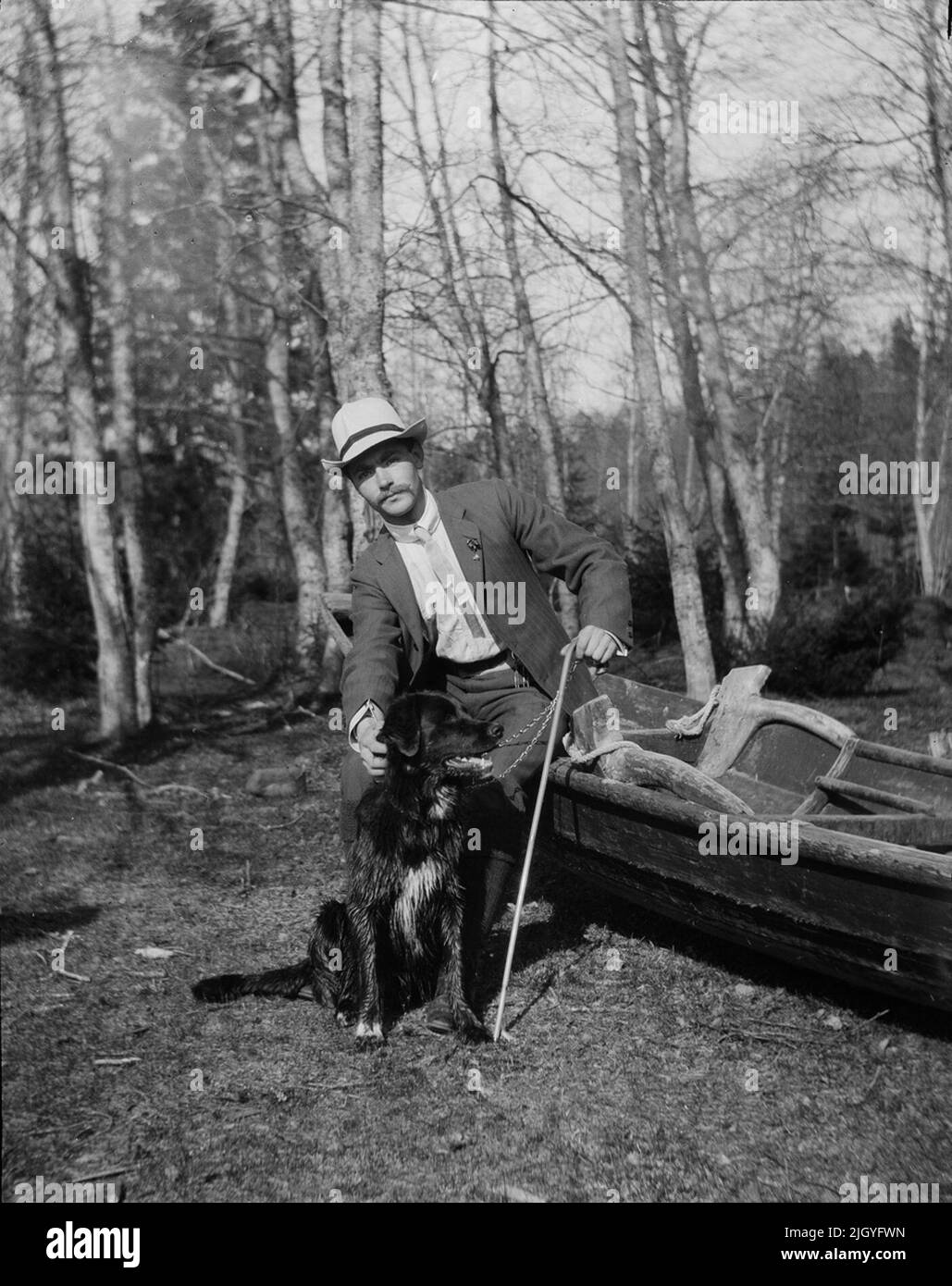 Josef Ärnström mit Hund auf dem Boot. Die Bildsammlung von Josef Ärnström wurde vom Upplands Museum 2011 erworben.Josef Ärnström wurde 1887 in Keps, Gemeinde Hållnäs, Uppland, geboren. Er war mit Nora Selldin, geboren in Timrå, Medelpad, verheiratet. Sowohl Josef als auch seine Frau Nora nahmen um 1910 am Lehrerseminar in Uppsalla ihren Abschluss. In Medelpad erhielt das Paar als frisch verheiratetes Paar zwischen 1910 und 12 ihre ersten Lehrerdienste an der Bergschule. Der Umzug ging dann nach Lappland, wo Josef zwischen 1913 und 18 in Toulleuvaara angestellt war. Joseph beendete seine Karriere als Übungslehrer ab etwa 19 Stockfoto