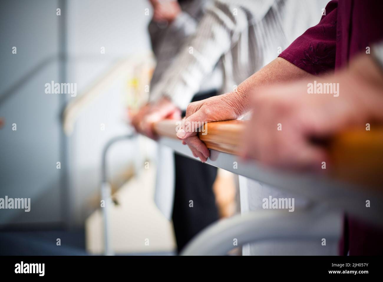 NAHAUFNAHME DER HÄNDE ÄLTERER BEWOHNERINNEN UND BEWOHNERINNEN MIT DER ÜBUNGSLEISTE FÜR TÄGLICHE ÜBUNGEN IN EINEM ALTENPFLEGEHEIM. NEW SOUTH WALES, AUSTRALIEN. Stockfoto