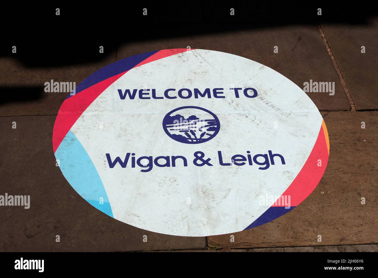 Willkommen in Wigan & Leigh, Schild auf Gehweg, Leigh Markt, Lancs, England, UK, WN7 4LA Stockfoto