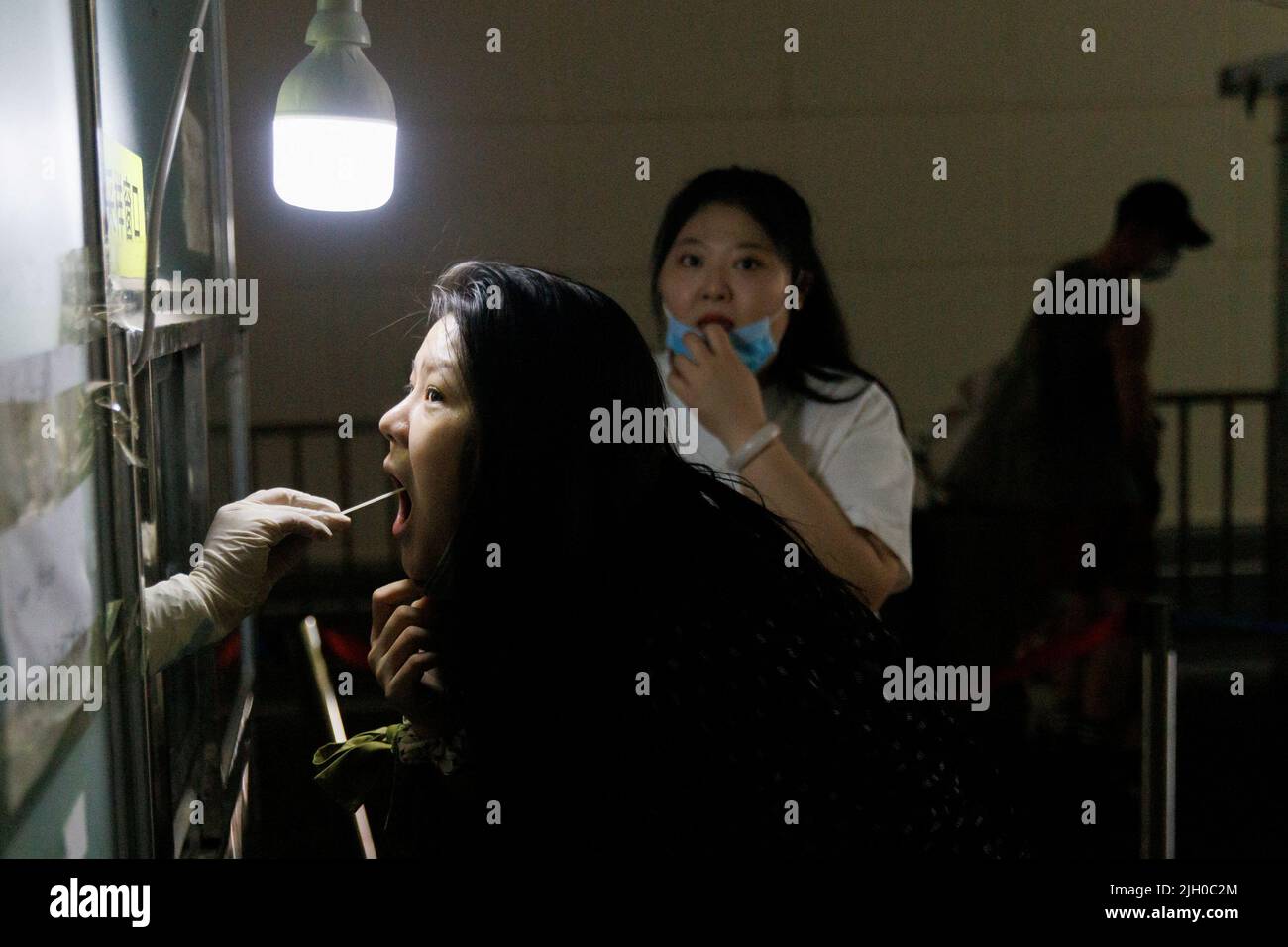 Eine Frau erhält nach einem Ausbruch der Coronavirus-Krankheit (COVID-19) in Peking, China, am 14. Juli 2022 einen Abstrichtest an einer Nukleinsäureteststation. REUTERS/Thomas Peter Stockfoto