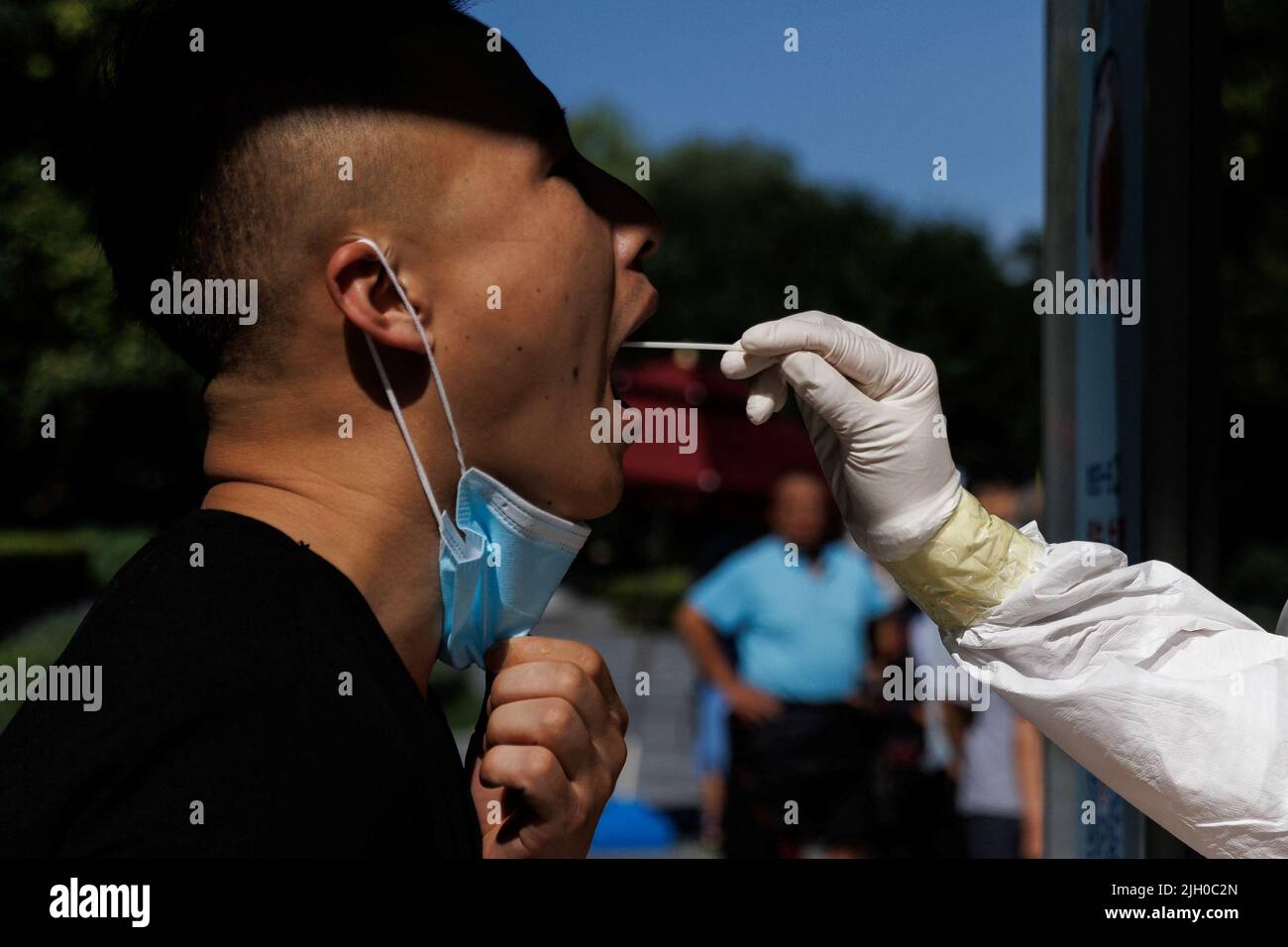 Ein Mann erhält nach einem Ausbruch der Coronavirus-Krankheit (COVID-19) in Peking, China, am 14. Juli 2022 einen Abstrichtest an einer Nukleinsäureteststation. REUTERS/Thomas Peter Stockfoto