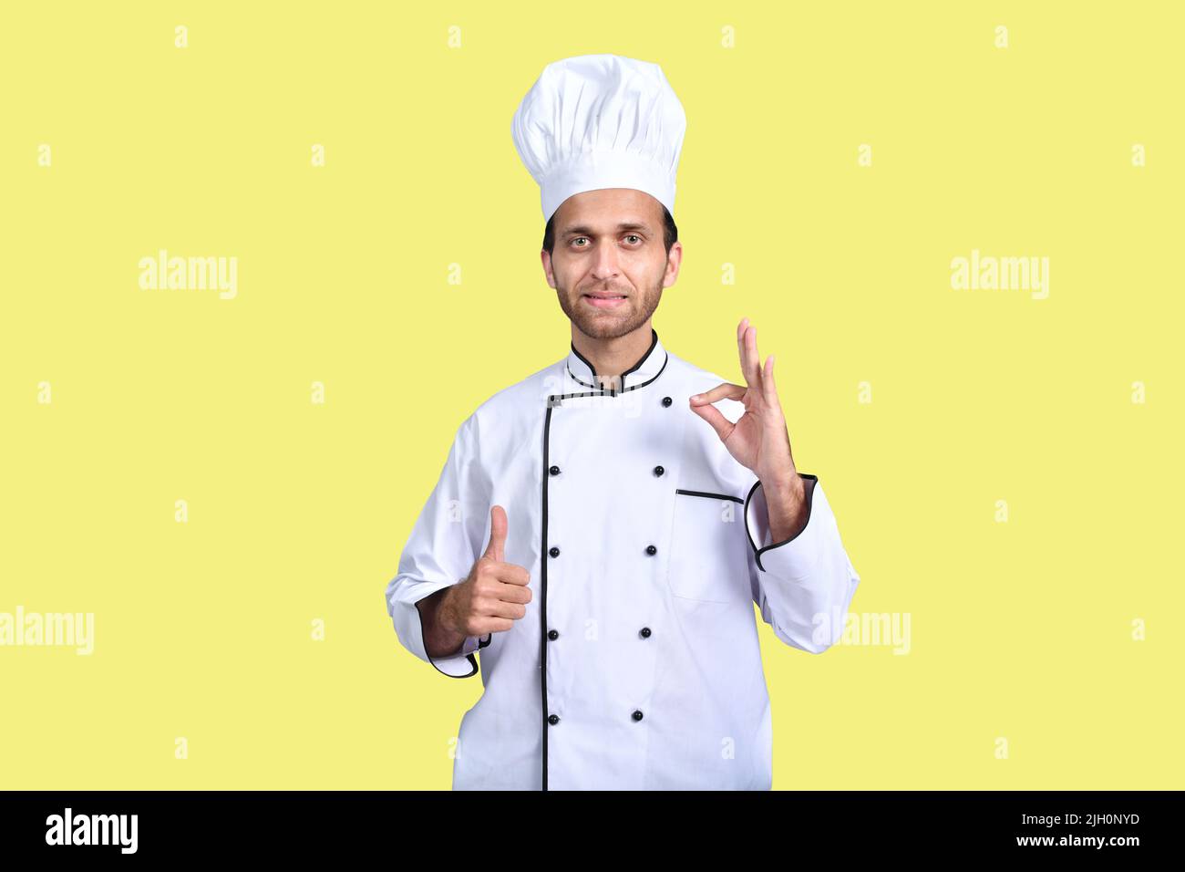 Der Chefkoch zeigt das Daumen-hoch-Zeichen und das perfekte Zeichen für Anerkennung Stockfoto