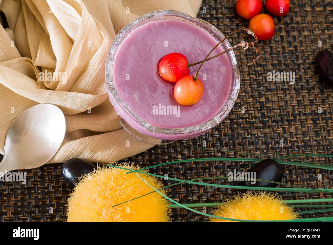 Jamun Mousse oder Black Plum Mousse gekrönt mit Kirschen.frisches, hausgemachtes veganes Dessert.Draufsicht, Nahaufnahme der Schüssel isoliert auf dunklem Hintergrund.Copy Space. Stockfoto