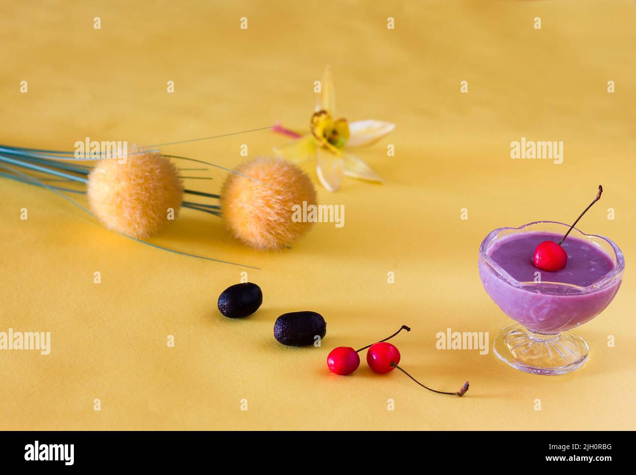 Jamun Mousse, Malabar Plum Fruit Mousse mit Kirschenauflage. Frisches, hausgemachtes Dessert aus Jamun. Sommerpudding auf dunkelgelbem Hintergrund, Nahaufnahme. Stockfoto