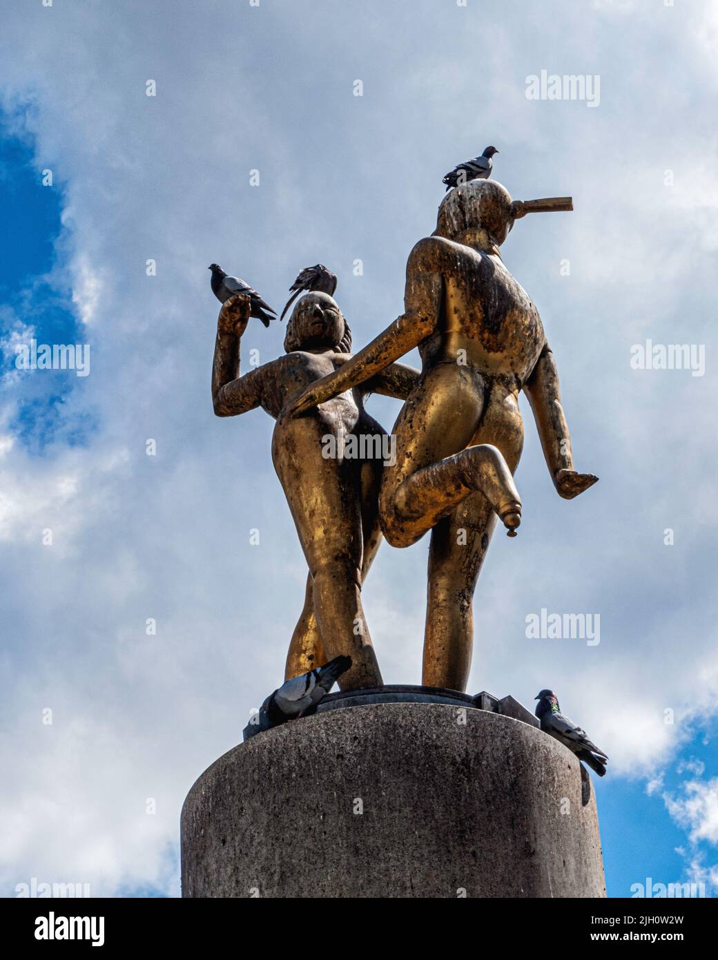 Bronzeskulptur „Tanzendes Paar“ des Bildhauers Joachim Schmettau mitten auf dem Hermannplatz, Neukölln, Berlin, Deutschland. Lieblingsplatz für Pigeo Stockfoto