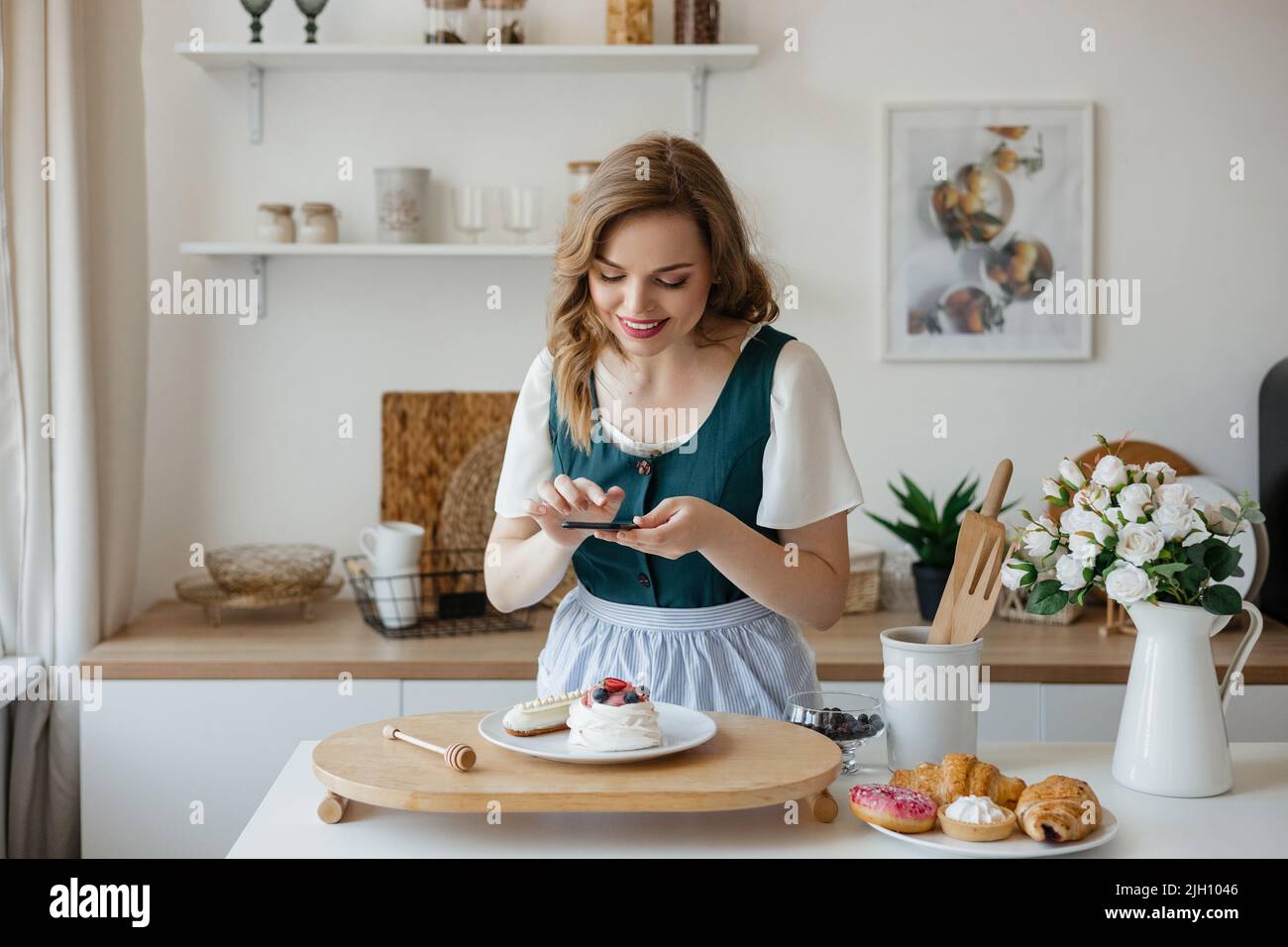 Schöne Mädchen Konditor macht ein Foto von einem Kuchen in der Küche Stockfoto