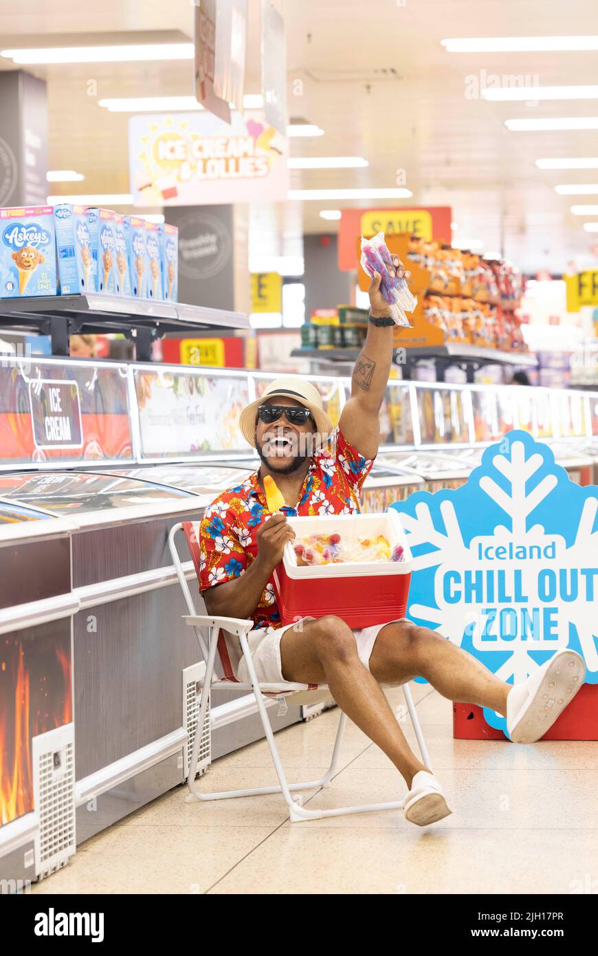 REDAKTIONELLE VERWENDUNG NUR Anton Thompson in der „Chill-out Zone“ eines isländischen Supermarkts in Islington, einem Sitzbereich im Gefriergang, der Kunden bei der aktuellen Hitzewelle dabei helfen soll, sich abzukühlen. Bilddatum: Donnerstag, 14. Juli 2022. Stockfoto