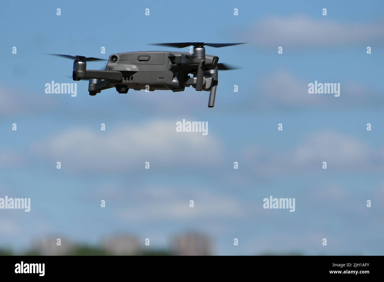 Grauer Quadcopter im Flug. Foto-Video-Luftaufnahmen. Stockfoto