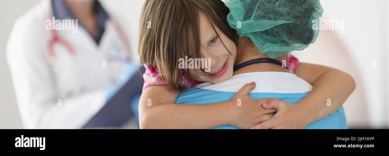 Das kleine Mädchen kletterte mit den Händen zum Arzt, um sich für die Hilfe zu bedanken Stockfoto