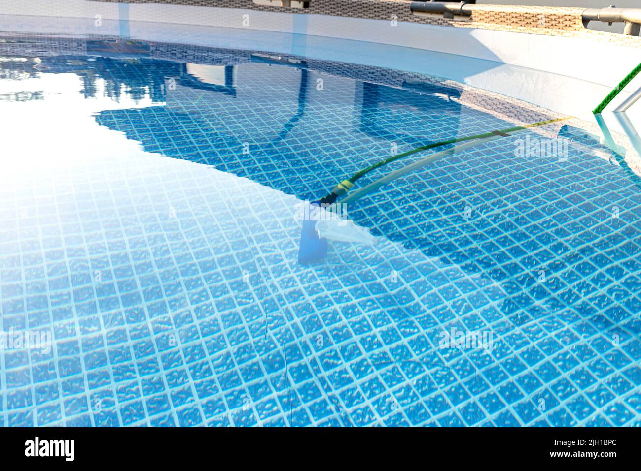 Reinigung des Hauses Pool im Garten mit einer Bürste, ziehen Schmutz vom Boden des Pools. Stockfoto