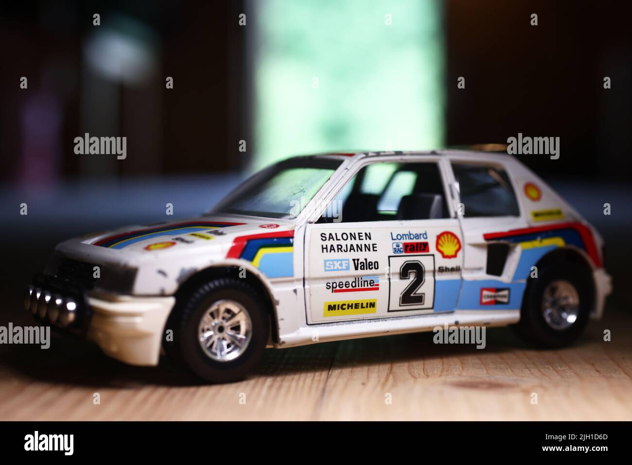 Spielzeug in einer Kiste auf dem Dachboden eines Hauses. Hier sind kleine Spielzeugautos, ein Peugeot 205 Turbo Rallye-Auto. Stockfoto