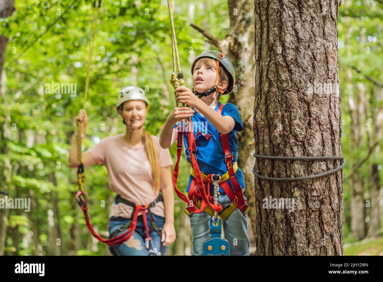 Mutter und Sohn klettern in extreme Straße Trolley Zipline im Wald auf ...
