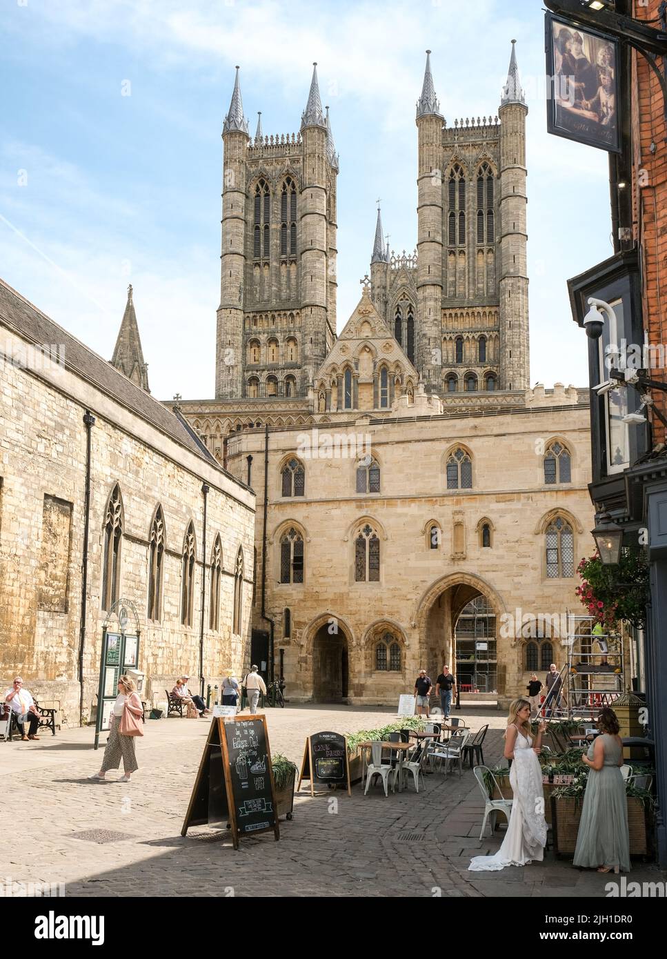 Lincoln, Lincolnshire, Großbritannien, Juni 16 2022. Elegant gekleidete Damen mit formellen Kleidern deuten auf eine bevorstehende Hochzeitsfeier vor der Lincoln Cathedral hin Stockfoto Lincoln, Lincolnshire, Großbritannien, Juni 16 2022. Elegant gekleidete Damen mit formellen Kleidern deuten auf eine bevorstehende Hochzeitsfeier vor der Lincoln Cathedral hin Stockfoto