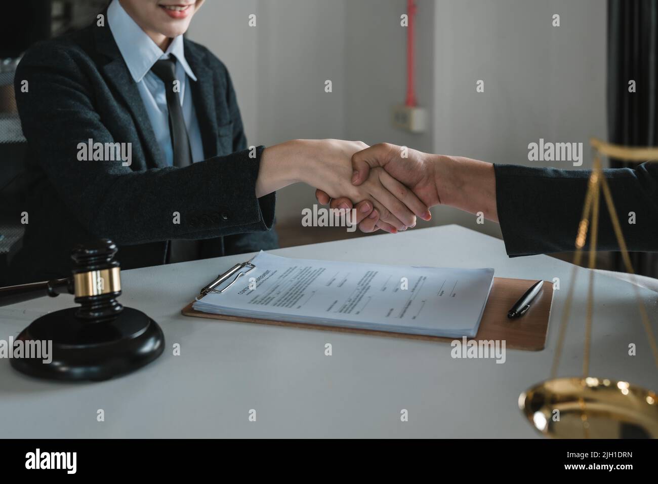 Der Anwalt handshake mit dem Mandanten, um die Vereinbarung in der Kanzlei zu beglückwünschen und zu bestätigen. Stockfoto