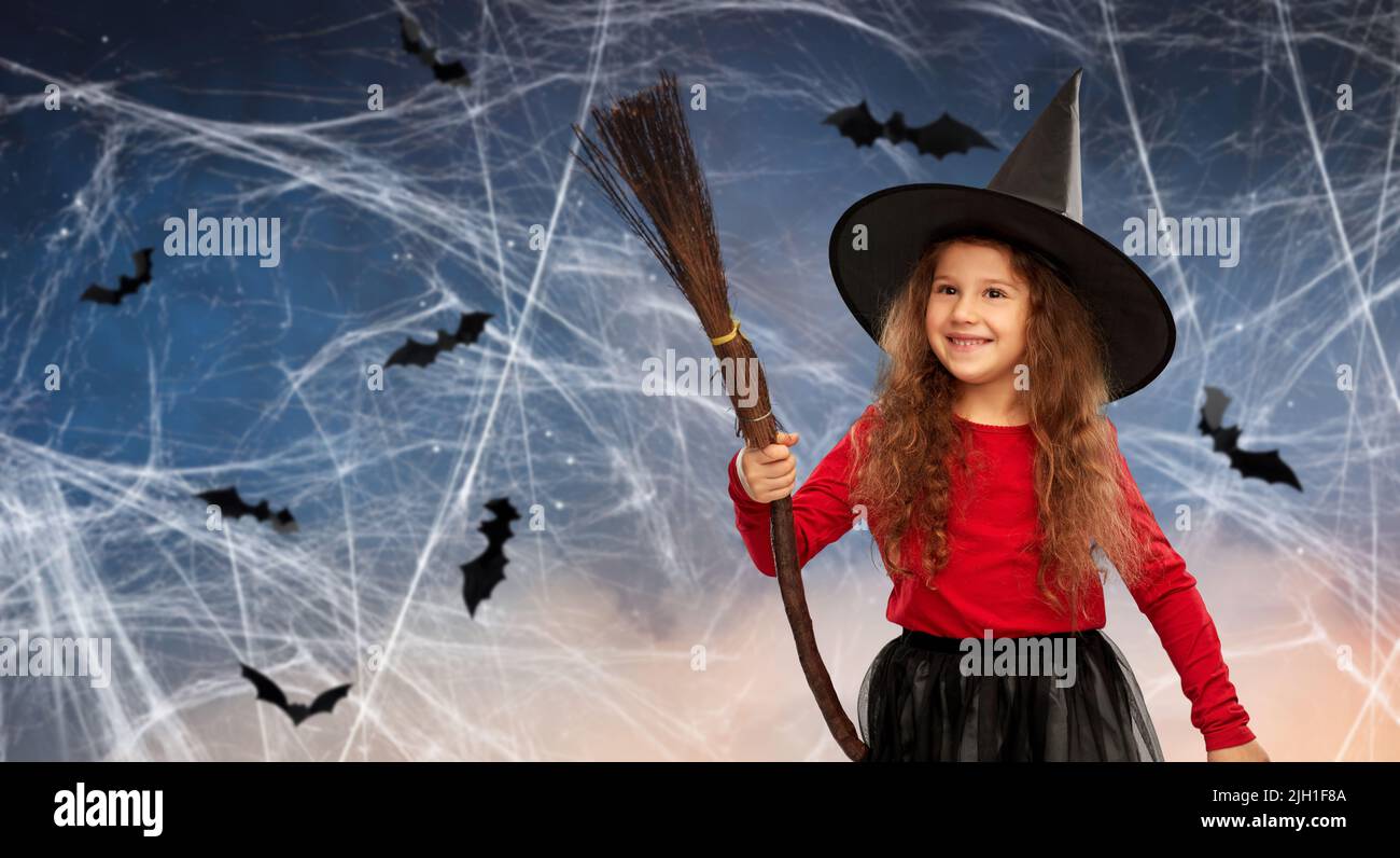 Mädchen in schwarzem Hexenhut mit Besen an halloween Stockfoto