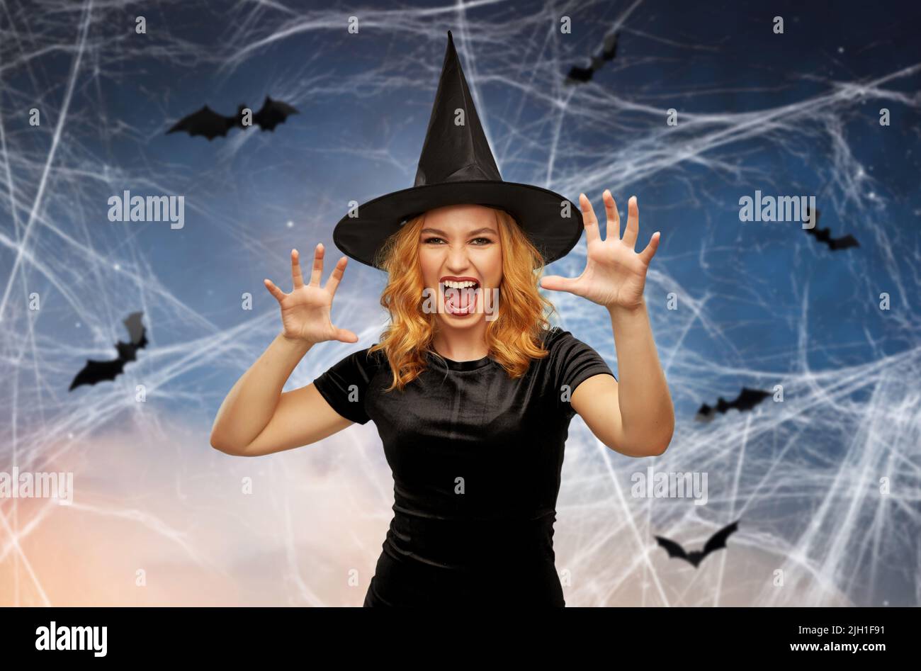 Gruselige Frau im schwarzen halloween Kostüm der Hexe Stockfoto