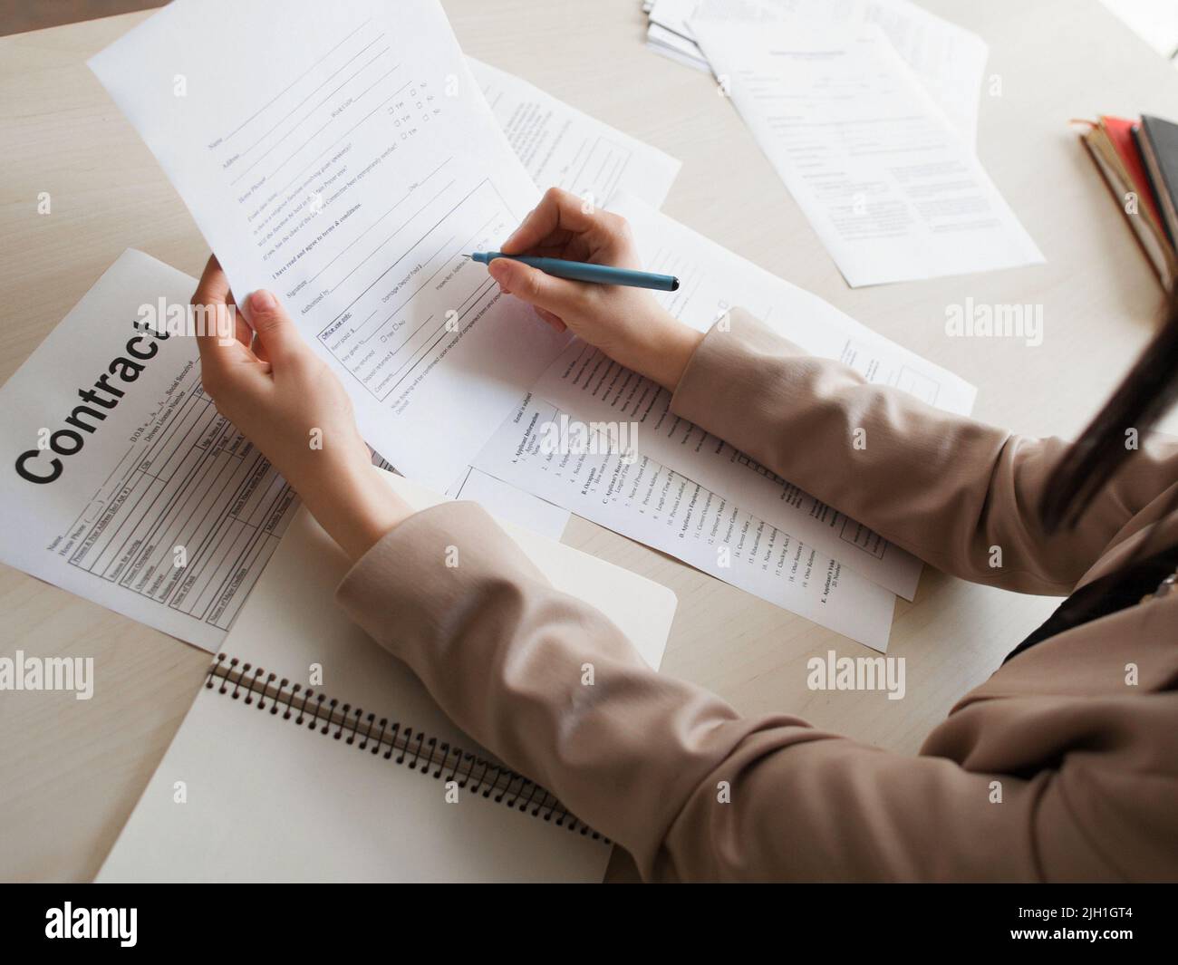 Frau, die einen Arbeitsvertrag unterzeichnet. Nahaufnahme der weiblichen Hände mit Stift, die das Dokument halten. Arbeit, Job, Beruf, Beruf, Rekrutierungskonzept Stockfoto