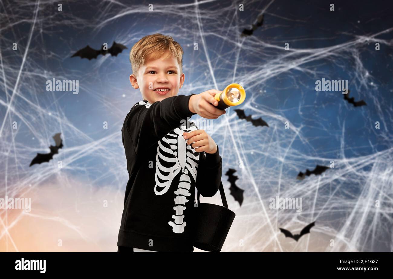 Junge mit Süßigkeiten und Taschenlampe an halloween Stockfoto