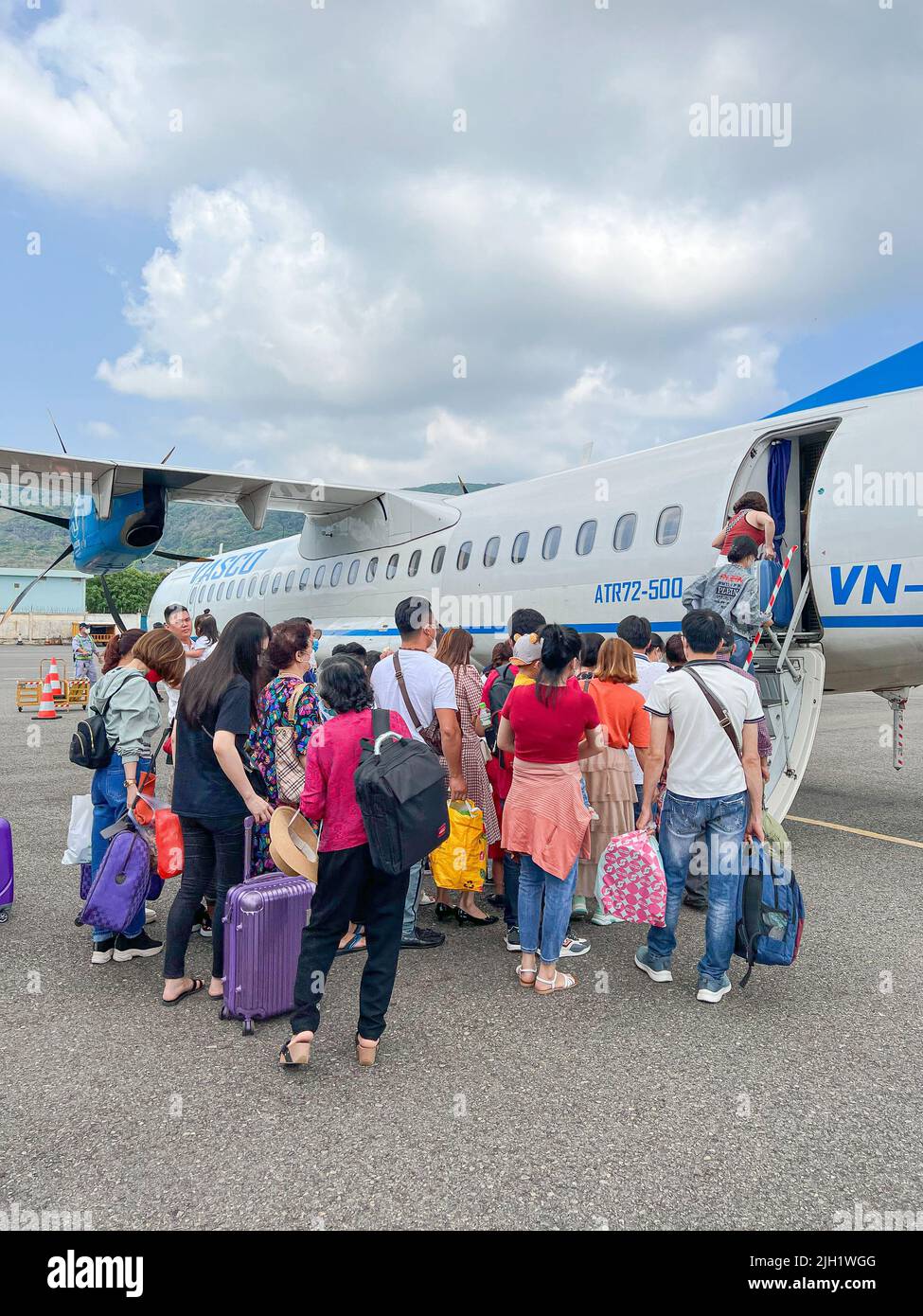 Menschen Touristen Passanten Abend an Bord eines Flugzeugs am Flughafen. Reisen Sie im Sommer mit dem Flugzeug. Stockfoto