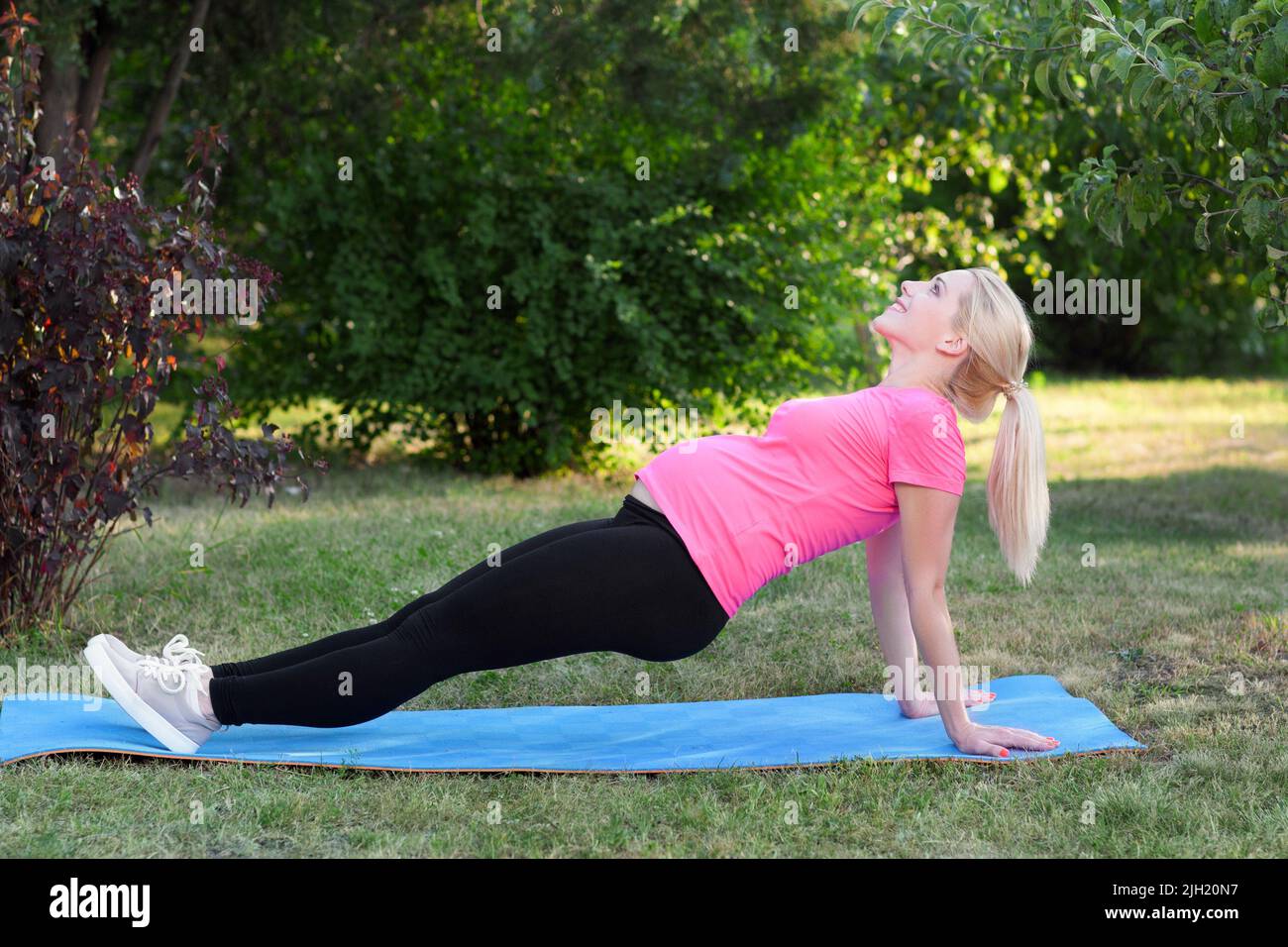 Junge Schwangeren Stretching im Freien, Fitness Stockfoto