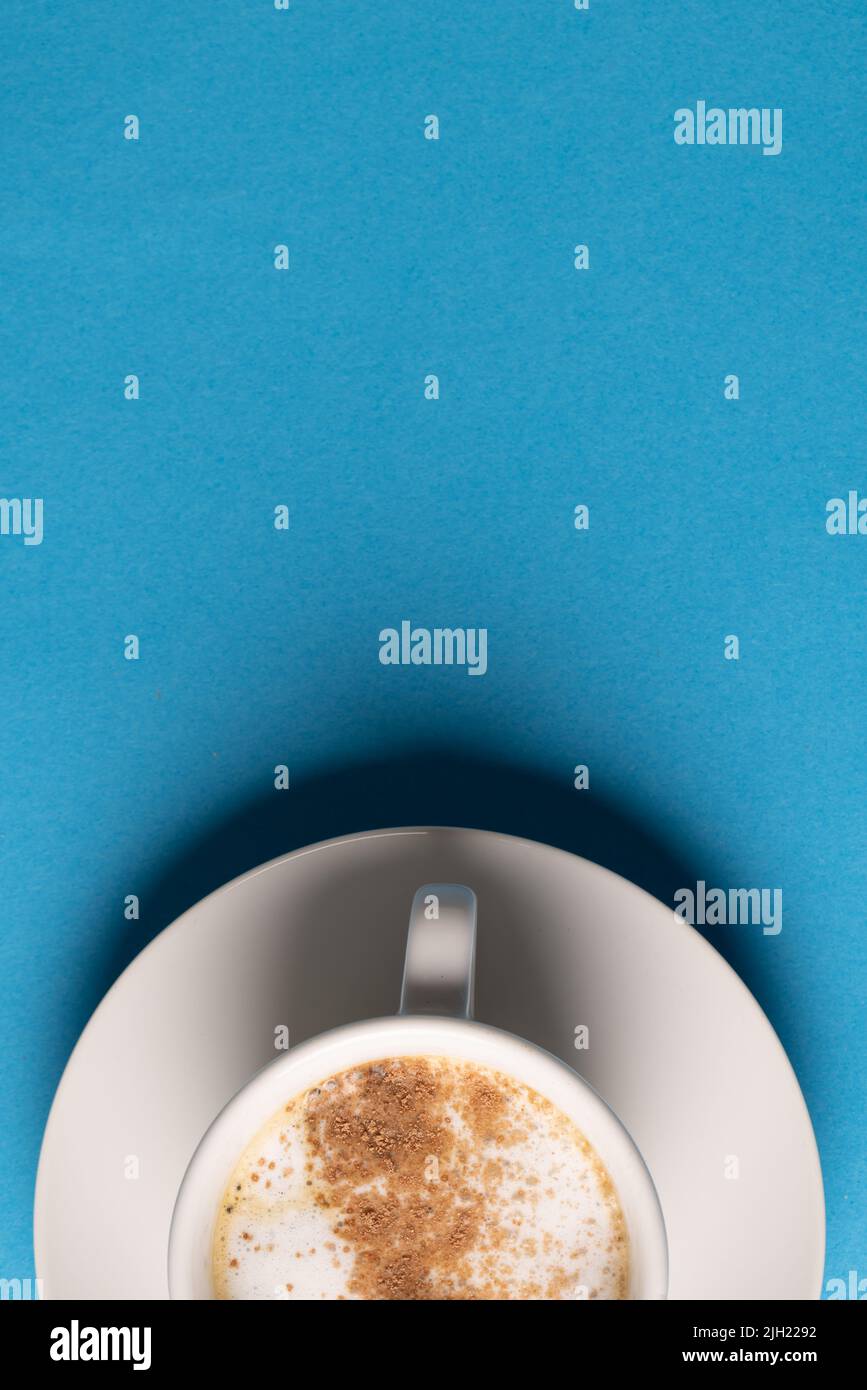 Bild einer weißen Tasse Kaffee mit Milch auf blauem Hintergrund Stockfoto