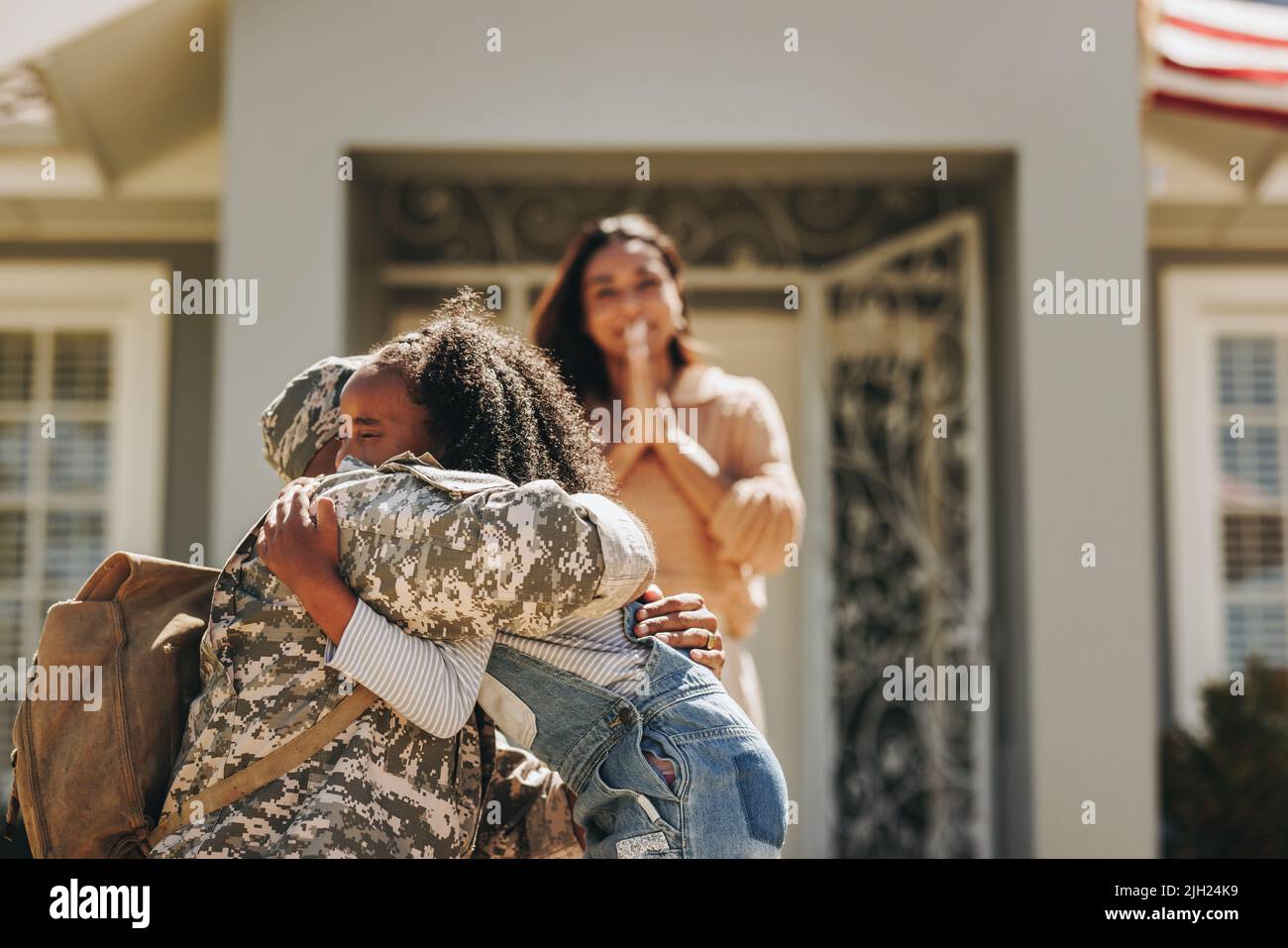 Militärangehöriger sagt Auf Wiedersehen zu seiner Familie, bevor er zum Krieg geht. Amerikanischer Militärangehöriger umarmt seine Tochter. Patriotischer Soldat, der seine Familie verlassen hat Stockfoto
