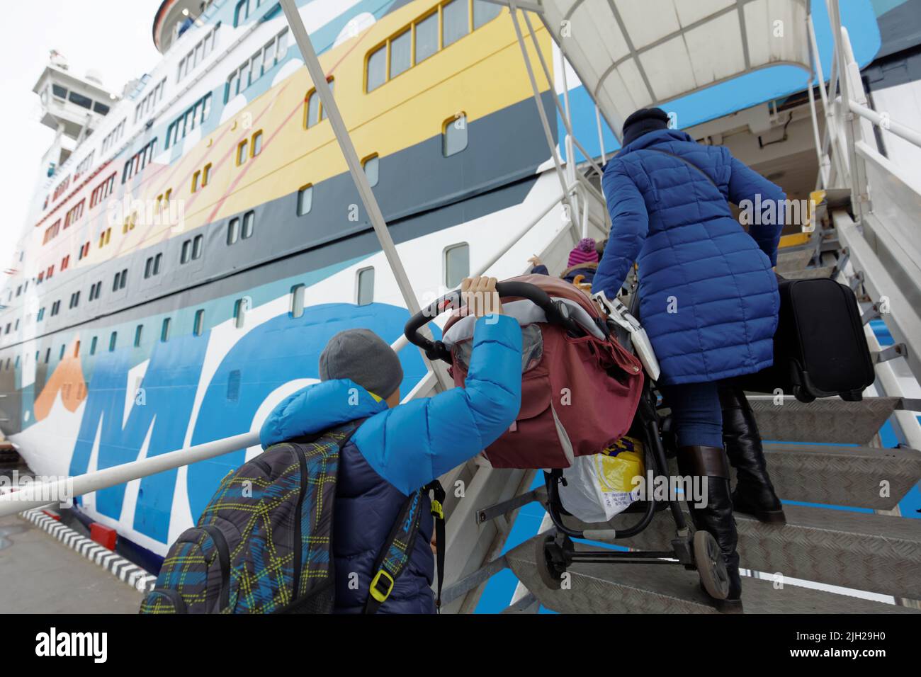 Familie mit Kinderwagen geht mit dem Mobi im Hafen von St. Petersburg, Russland, die Gangplanke hinauf zum Kreuzfahrtschiff „Princess Anastasia“ Stockfoto