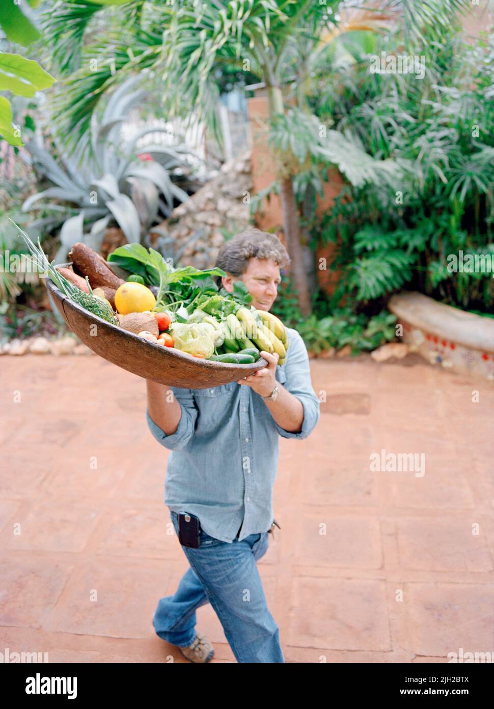 Jake's Resort Besitzer Jason Henzell bringt eine Platte mit Bio-Obst und Gemüse von lokalen Bauernhöfen in die Küche im Jake's Resort. Jamaika Stockfoto