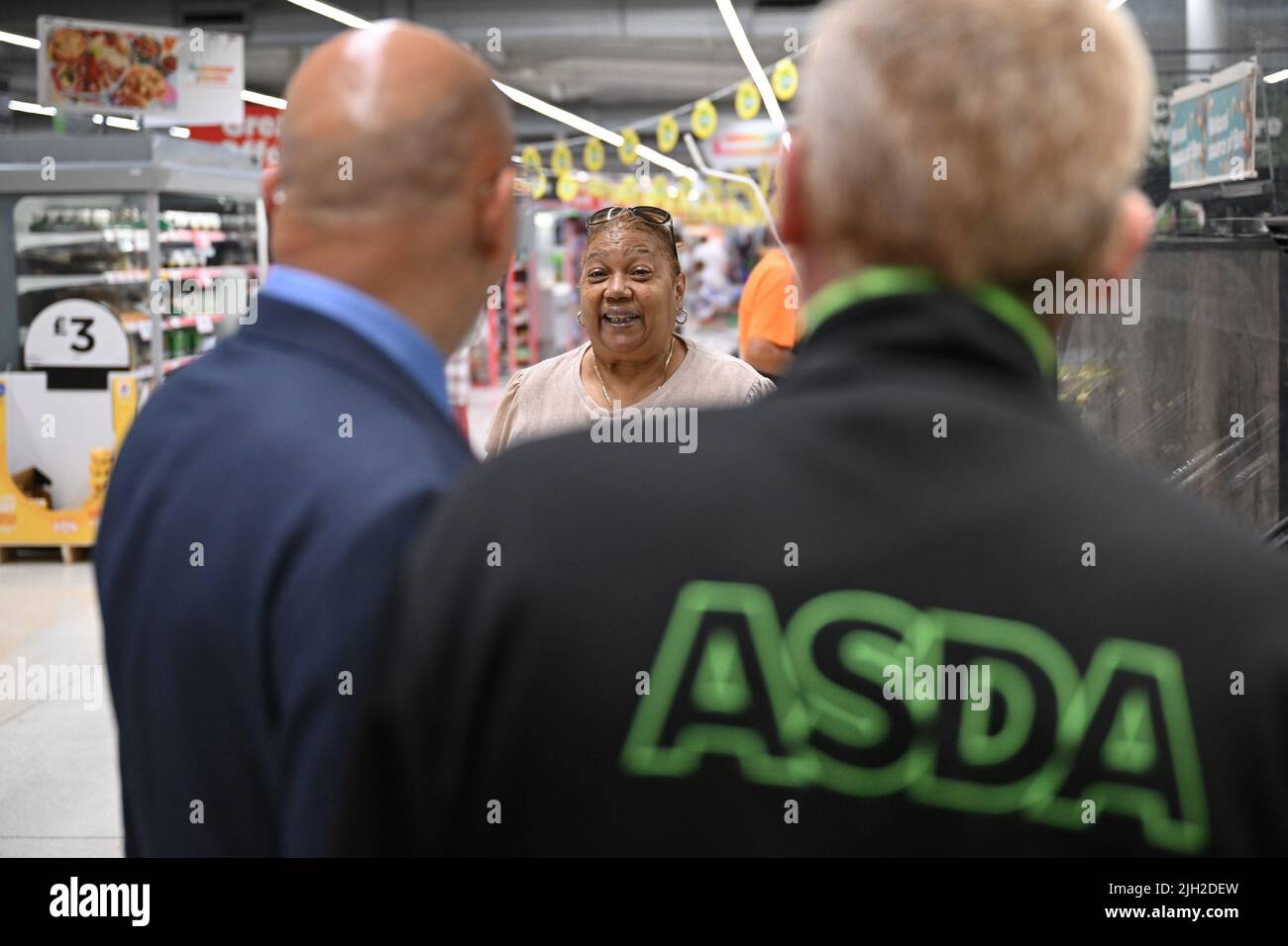 Schatzkanzler Nadhim Zahawi (links) spricht mit einem Kunden während seines Besuchs in einem Asda-Geschäft in London, um die ersten Kosten für Lebenshaltungszahlungen zu markieren. Bilddatum: Donnerstag, 14. Juli 2022. Stockfoto