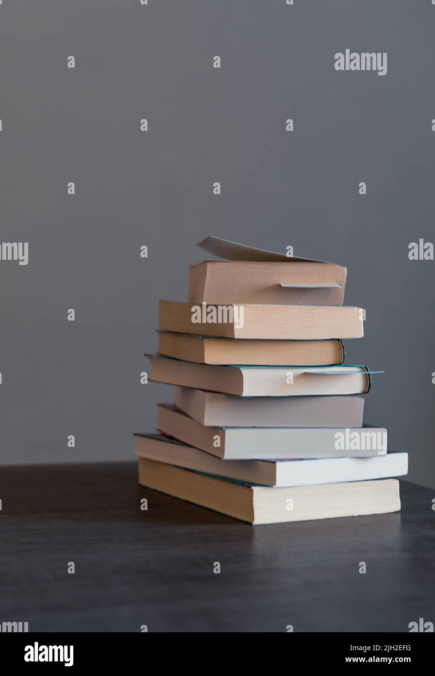 Stapel von Büchern, die zum Lesen bereit sind oder die am Book Day auf einem Holztisch gelesen wurden Stockfoto