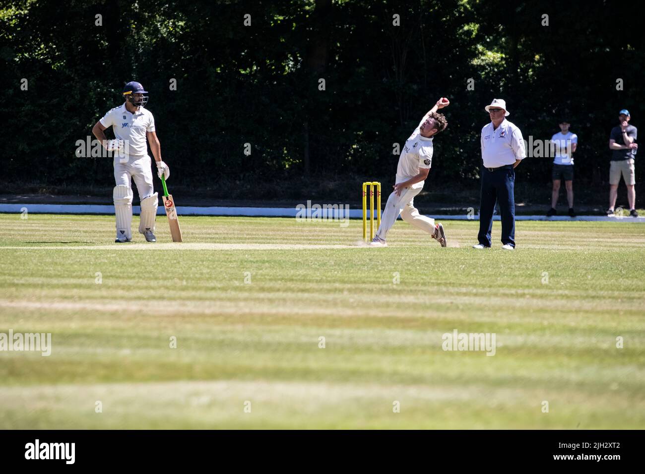Ein schneller Bowler nähert sich den Stumps, um den Batsman in einem Cricket-Spiel der Sommerliga in Huddersfield, Yorkshire, England, anzustoßen Stockfoto
