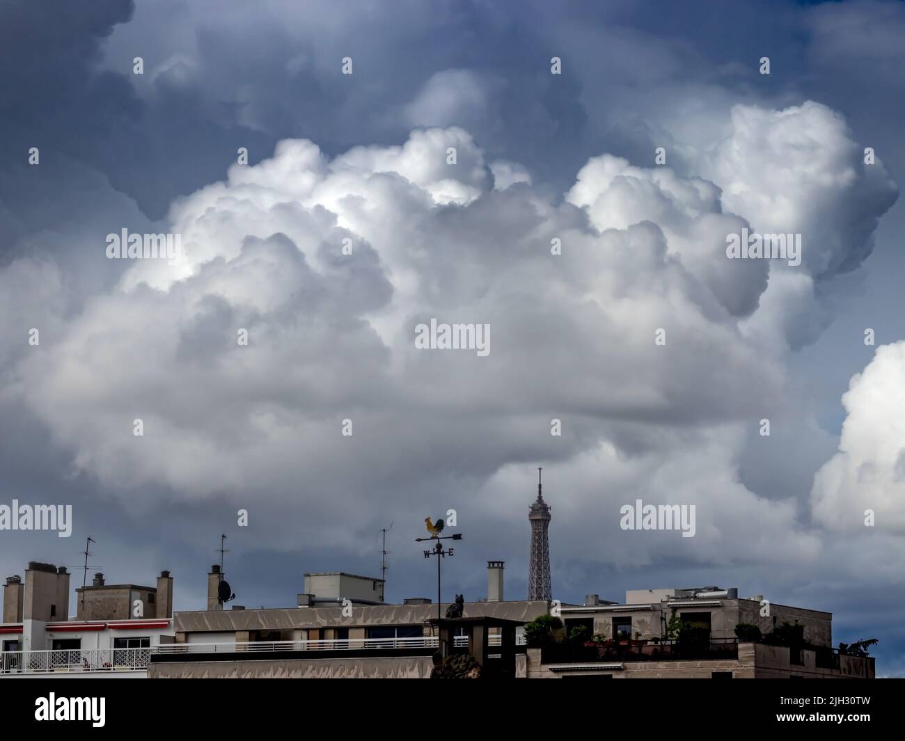 PARIS / FRANKREICH - 12. JUNI 2019: Skyline von Paris bei Tageslicht mit dramatischen Wolken und Eiffelturm im Hintergrund Stockfoto