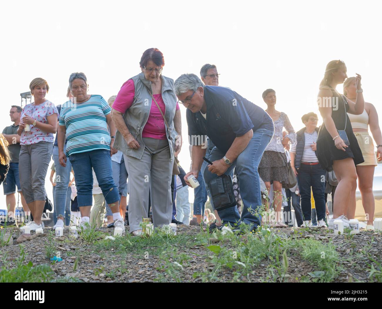 Schuld, Deutschland. 14.. Juli 2022. Zur Erinnerung an die Opfer der Flutkatastrophe zünden Menschen weiße Kerzen an den Ufern der Ahr in Schuld an. Schuld war von den Wassermassen extrem zerstört worden. Quelle: Boris Roessler/dpa/Alamy Live News Stockfoto