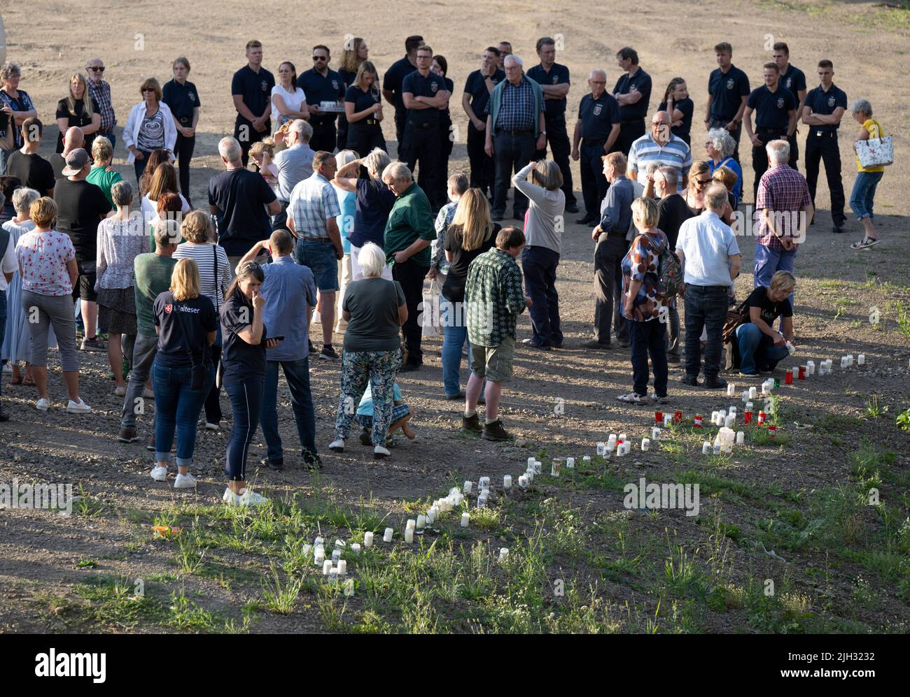 Schuld, Deutschland. 14.. Juli 2022. Zum Gedenken an die Opfer der Flutkatastrophe zünden Menschen Kerzen an den Ufern der Ahr in Schuld an und halten ein stilles Gedenken ab. Schuld war von den Wassermassen extrem zerstört worden. Quelle: Boris Roessler/dpa/Alamy Live News Stockfoto