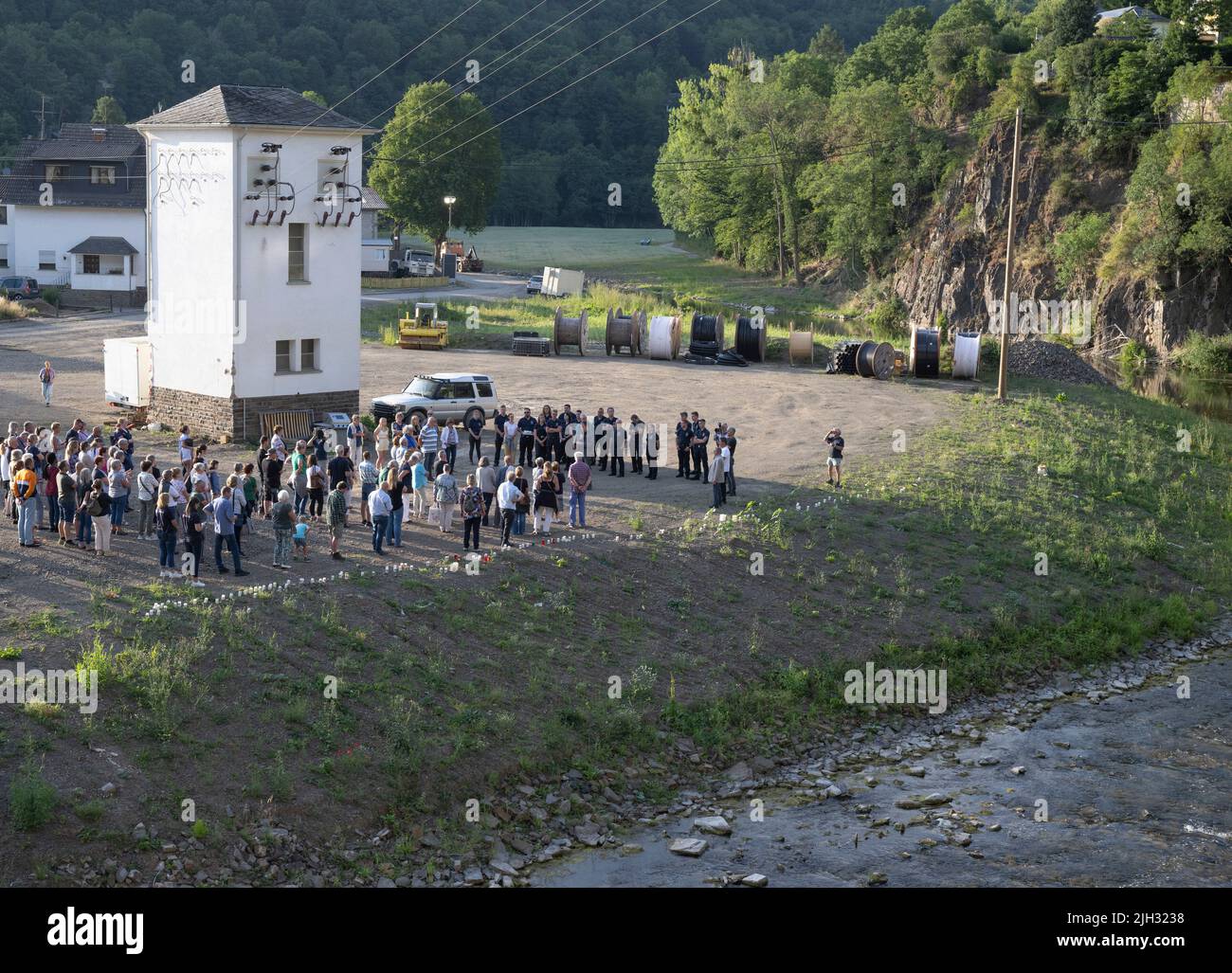 Schuld, Deutschland. 14.. Juli 2022. Zum Gedenken an die Opfer der Flutkatastrophe zünden Menschen Kerzen an den Ufern der Ahr in Schuld an und halten ein stilles Gedenken ab. Schuld war von den Wassermassen extrem zerstört worden. Quelle: Boris Roessler/dpa/Alamy Live News Stockfoto
