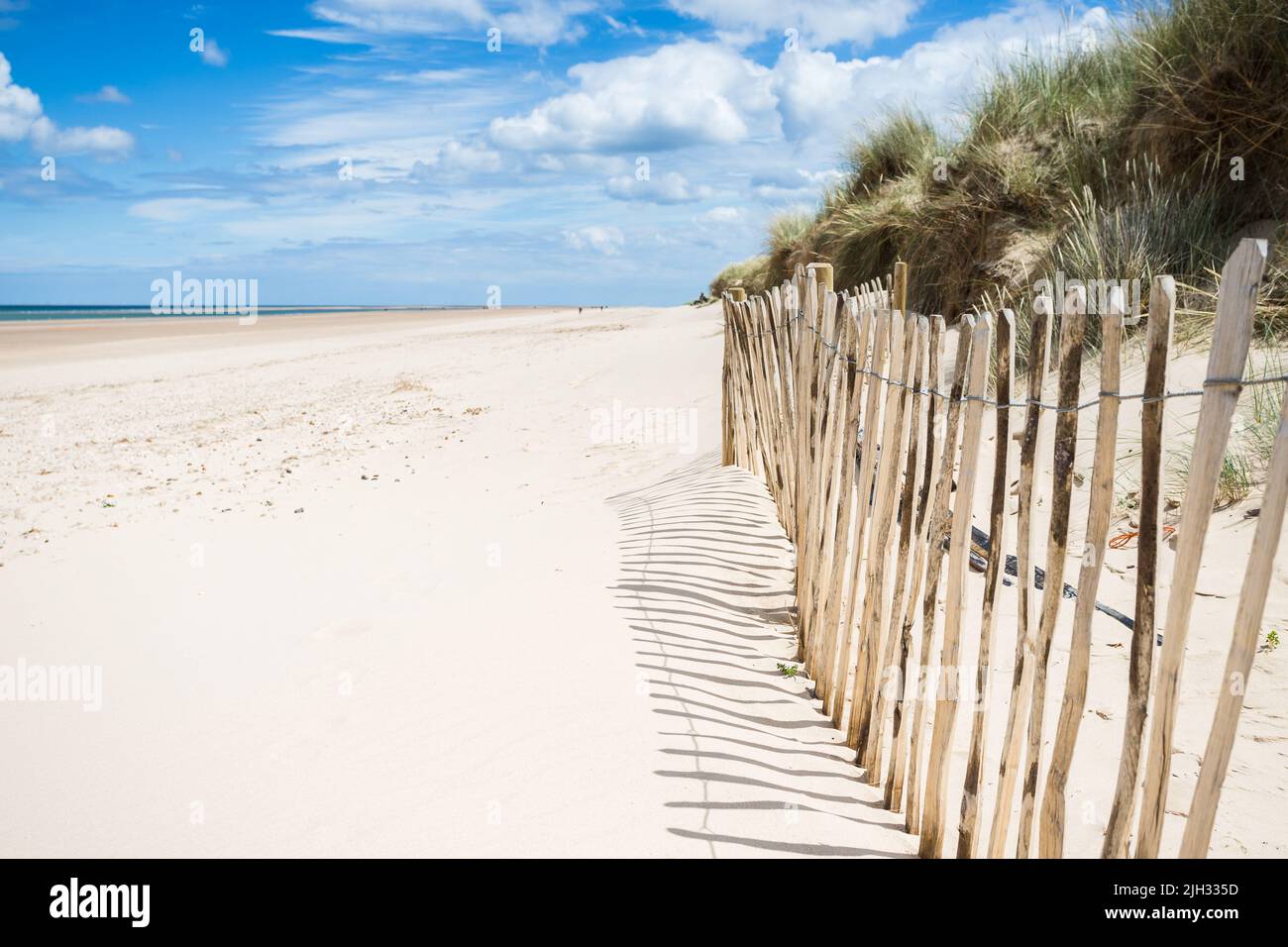 Ein Zaun umzäunt einen Teil des schönen Strandes von Holkham an der Nordnorfolk-Küste, der die Sanddünen schützt. Stockfoto