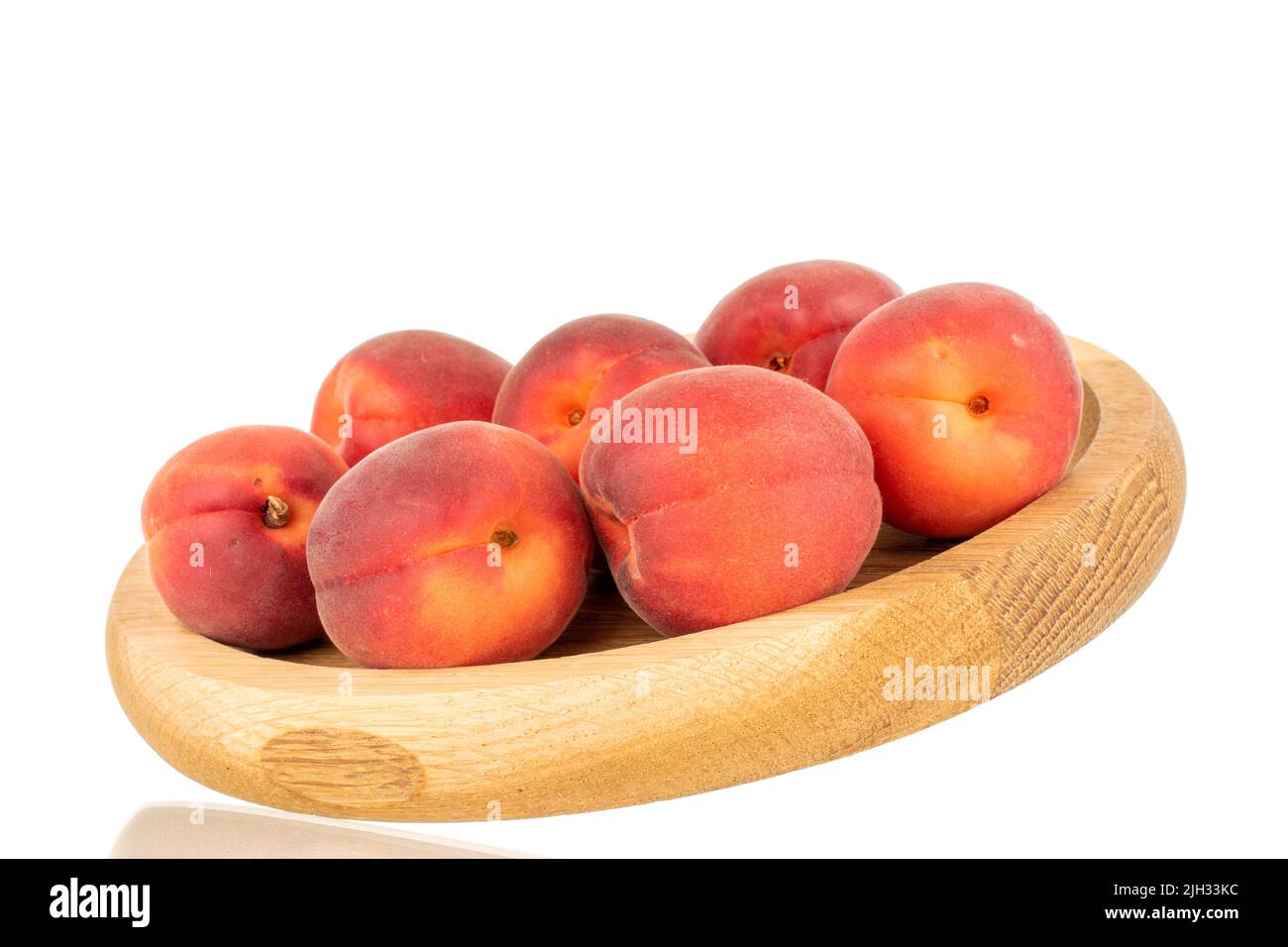 Mehrere reife rote Aprikosen auf einem Holztablett, Nahaufnahme, isoliert auf weißem Hintergrund. Stockfoto