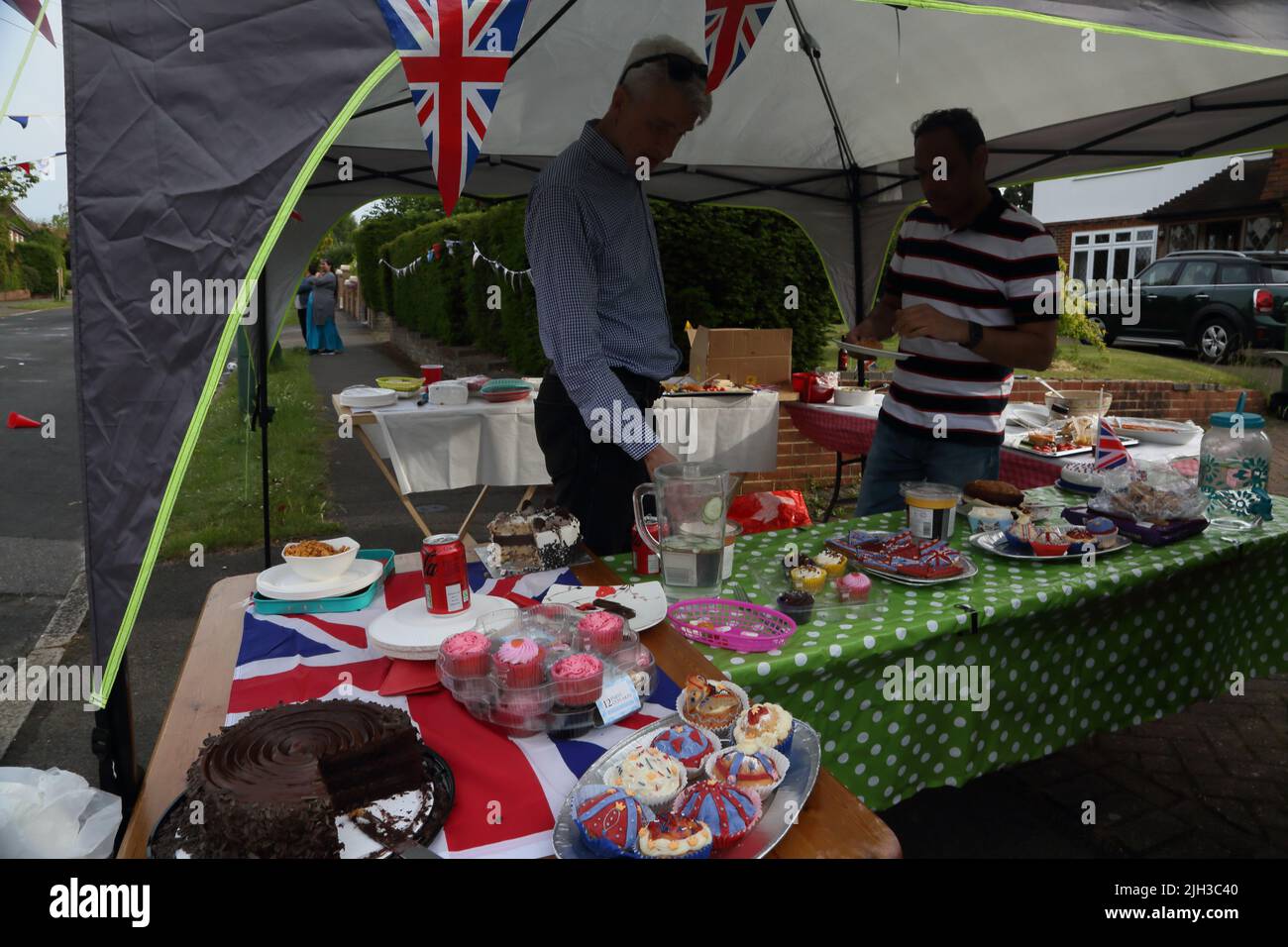 Men by Cake Stand bei der Street Party zur Feier des Platinum Jubilee von Queen Elizabeth II in Surrey England Stockfoto