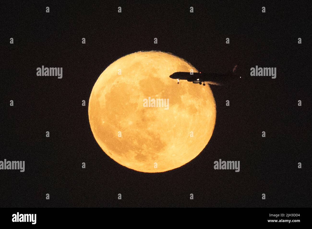 Kairo, Ägypten. 14.. Juli 2022. Ein Flugzeug wird am 14. Juli 2022 gegen den Supermond über Kairo, Ägypten, silhouettiert. Quelle: Ahmed Gomaa/Xinhua/Alamy Live News Stockfoto