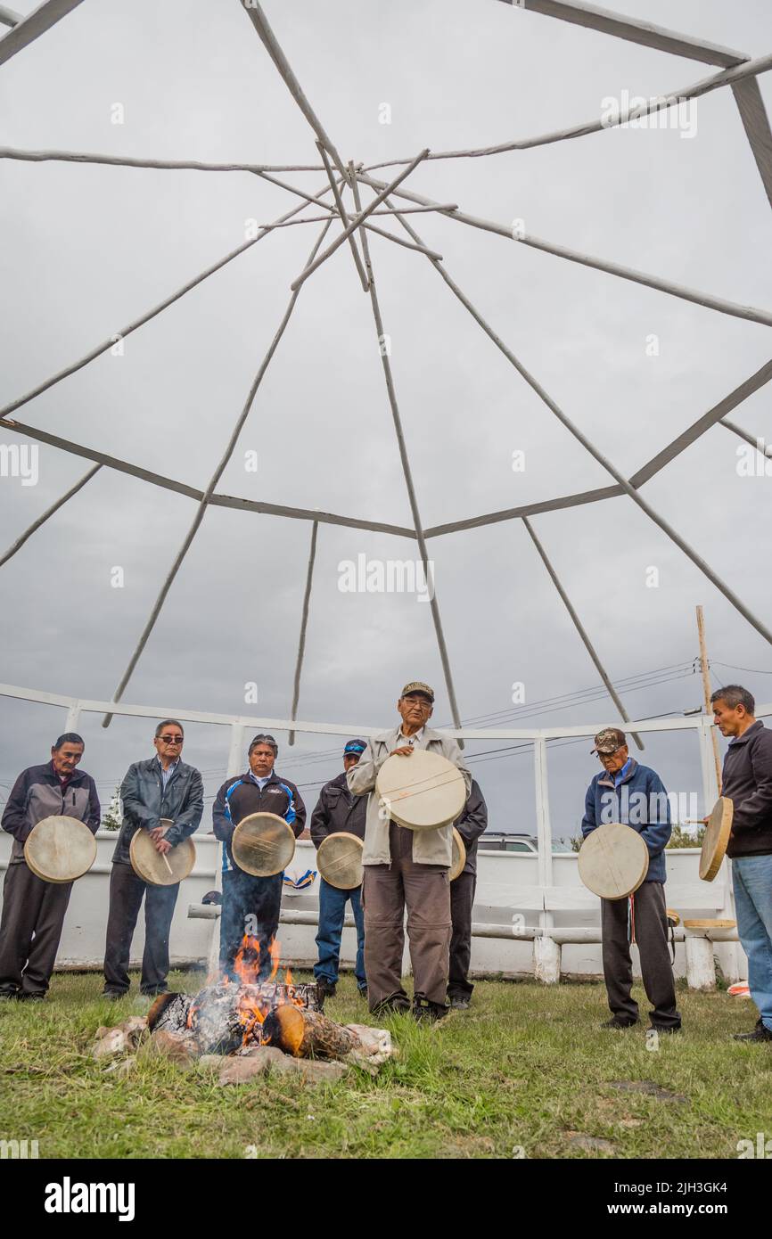 Indigene Dene Männer bei der Feuerfütterung in der nördlichen Gemeinschaft von Deline, Northwest Territories, Kanada Stockfoto