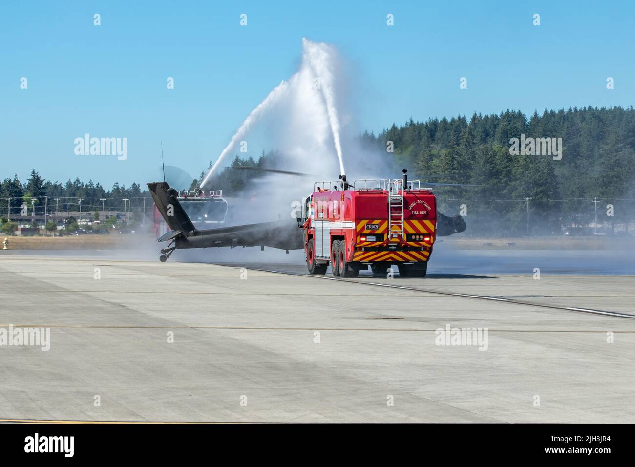 Col. Shane Finison, Kommandant der 16. Combat Aviation Brigade, taxis am 11. Juli 2022 einen AH-64E Apache Hubschrauber unter Feuer LKW Wasserspray auf dem Grey Army Airfield, Washington. Dies war der letzte Flug für Col. Finison als Brigadekommandeur. (USA Foto der Armee von Capt. Kyle Abraham, 16. Combat Aviation Brigade) Stockfoto